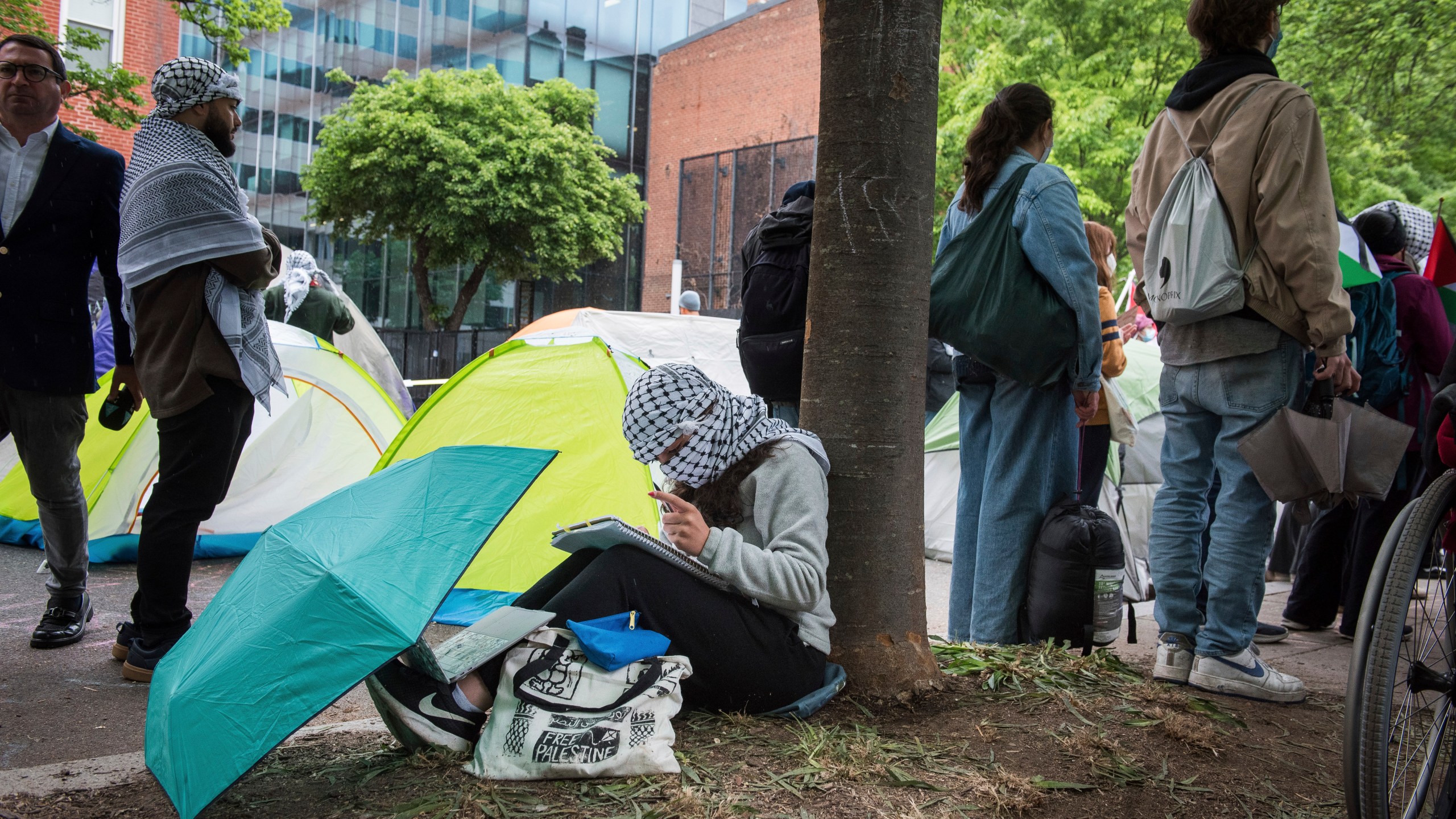 A George Washington University student, who declined to give her name, works on a school assignment while joining other students in protesting the Israel-Hamas war at George Washington University in Washington, Saturday, April 27, 2024. Protests and encampments have sprung up on college and university campuses across the country to protest the war. (AP Photo/Cliff Owen)