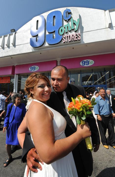 Denisse Navarro and Guadalupe Villagrana embrace after their 99 cent wedding ceremony held at the 99 cent store in Los Angeles on September 9, 2009. The budget supermarket chain helped nine happy California couples beat the recession blues by offering cut-price wedding ceremonies -- for just 99 cents each. The 99 Cents Only Stores chain is picking up the tab for nine couples at its branch on Sunset Boulevard in the heart of Hollywood on Wednesday to mark the ninth day of the nine month in 2009. After getting hitched, the nine couples were handed 99 dollars and 99 cents in cash before being whisked off to an undisclosed "famous romantic Los Angeles" location. AFP PHOTO/Mark RALSTON (Photo credit should read MARK RALSTON/AFP via Getty Images)