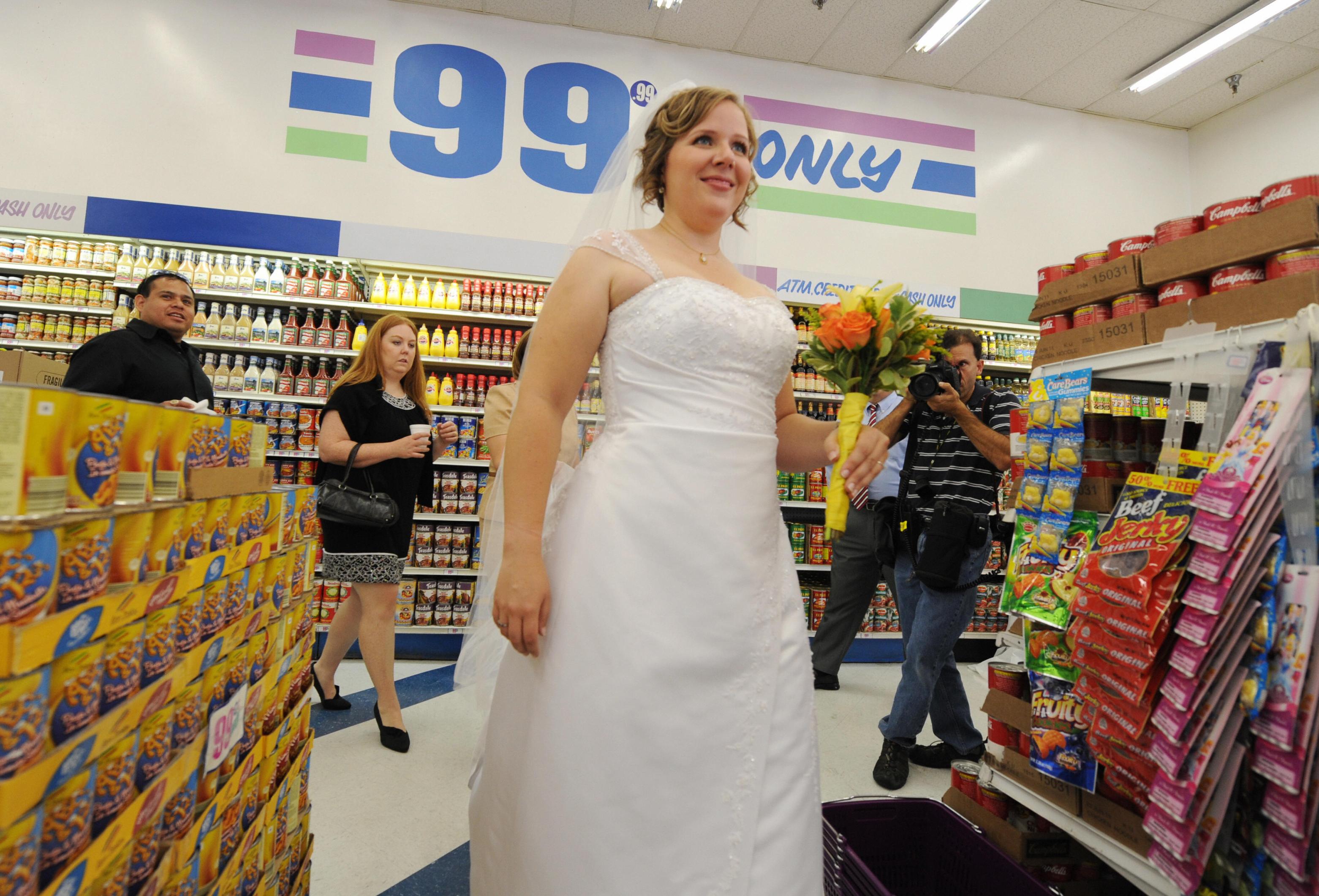 Emily Wiley waits amongst the food aisles before her 99 cent wedding ceremony at the 99 cent store in Los Angeles on September 9, 2009. The budget supermarket chain helped nine happy California couples beat the recession blues by offering cut-price wedding ceremonies -- for just 99 cents each. The 99 Cents Only Stores chain is picking up the tab for nine couples at its branch on Sunset Boulevard in the heart of Hollywood on Wednesday to mark the ninth day of the nine month in 2009. After getting hitched, the nine couples were handed 99 dollars and 99 cents in cash before being whisked off to an undisclosed "famous romantic Los Angeles" location. AFP PHOTO/Mark RALSTON (Photo credit should read MARK RALSTON/AFP via Getty Images)