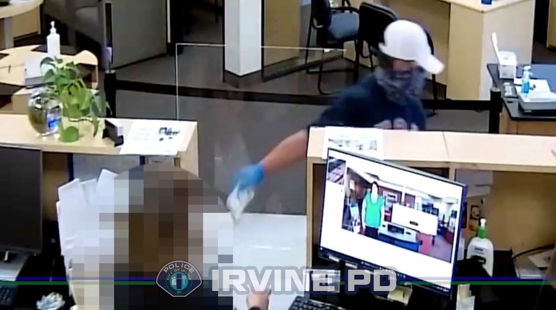 A male suspect seen on grabbing a stack of cash during a bank robbery in Irvine on April 2, 2024 (Irvine Police Department)