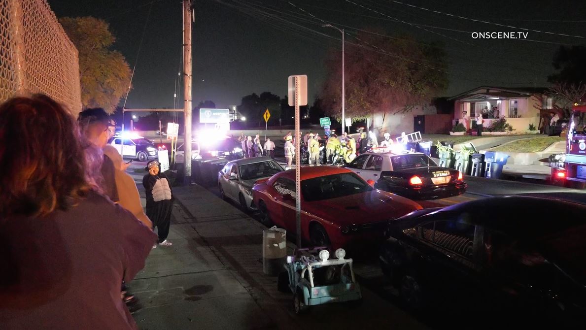 A crowd of bystanders watching crews clean up a wreckage and auto debris after a pursuit crash in Boyle Heights on April 23, 2024. (OnScene.TV)