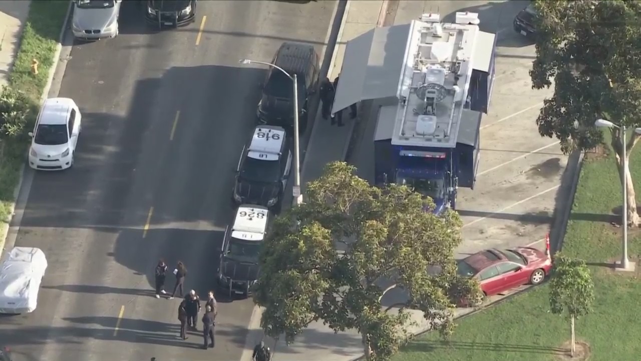 Bystanders watch from behind police tape after a man was fatally shot in Long Beach's MacArthur Park on April 17, 2024. (KTLA)