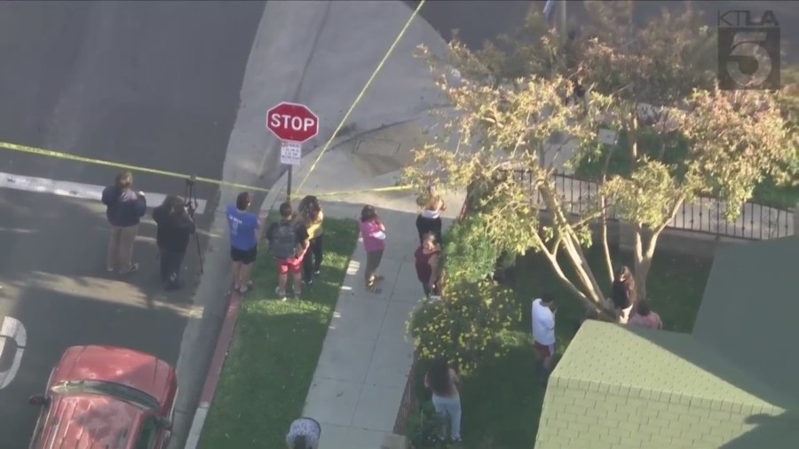 Bystanders watch from behind police tape after a man was fatally shot in Long Beach's MacArthur Park on April 17, 2024. (KTLA)