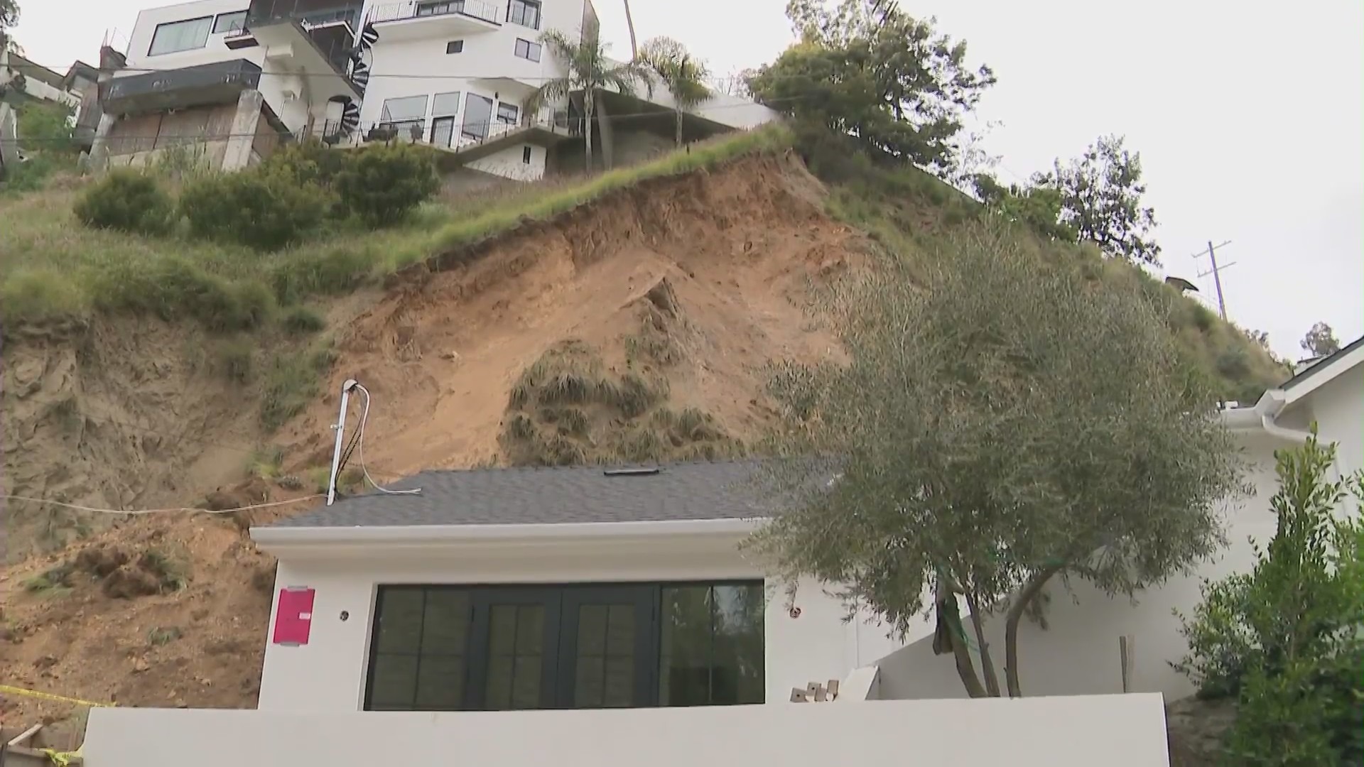 A Hollywood Hills home was partially buried by a large landslide as more homes loom above on April 4, 2024. (KTLA)