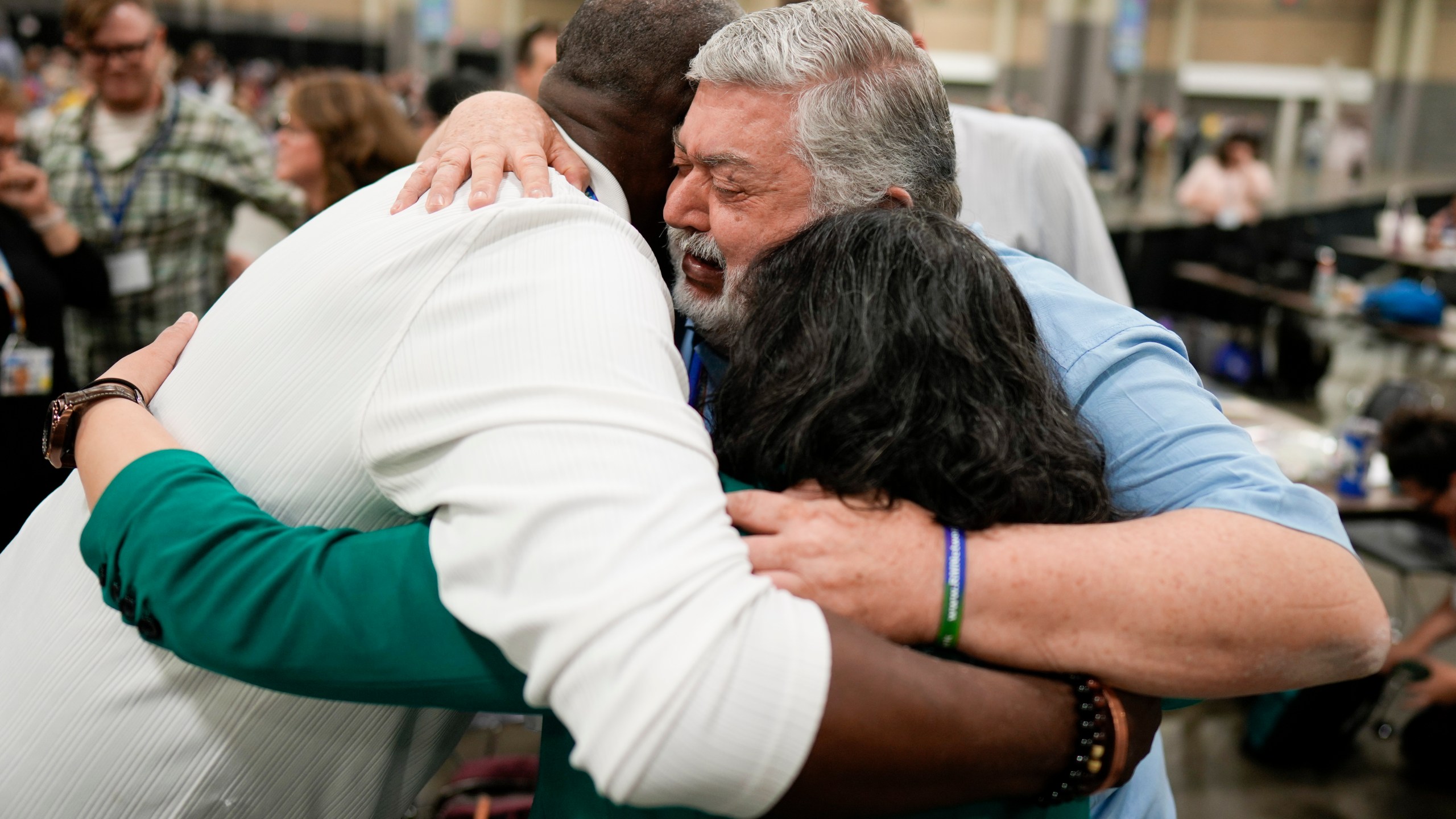 David Meredith, middle, hugs fellow observers after an approval vote at the United Methodist Church General Conference Wednesday, May 1, 2024, in Charlotte, N.C. United Methodist delegates repealed their church’s longstanding ban on LGBTQ clergy with no debate on Wednesday, removing a rule forbidding “self-avowed practicing homosexuals” from being ordained or appointed as ministers. (AP Photo/Chris Carlson)