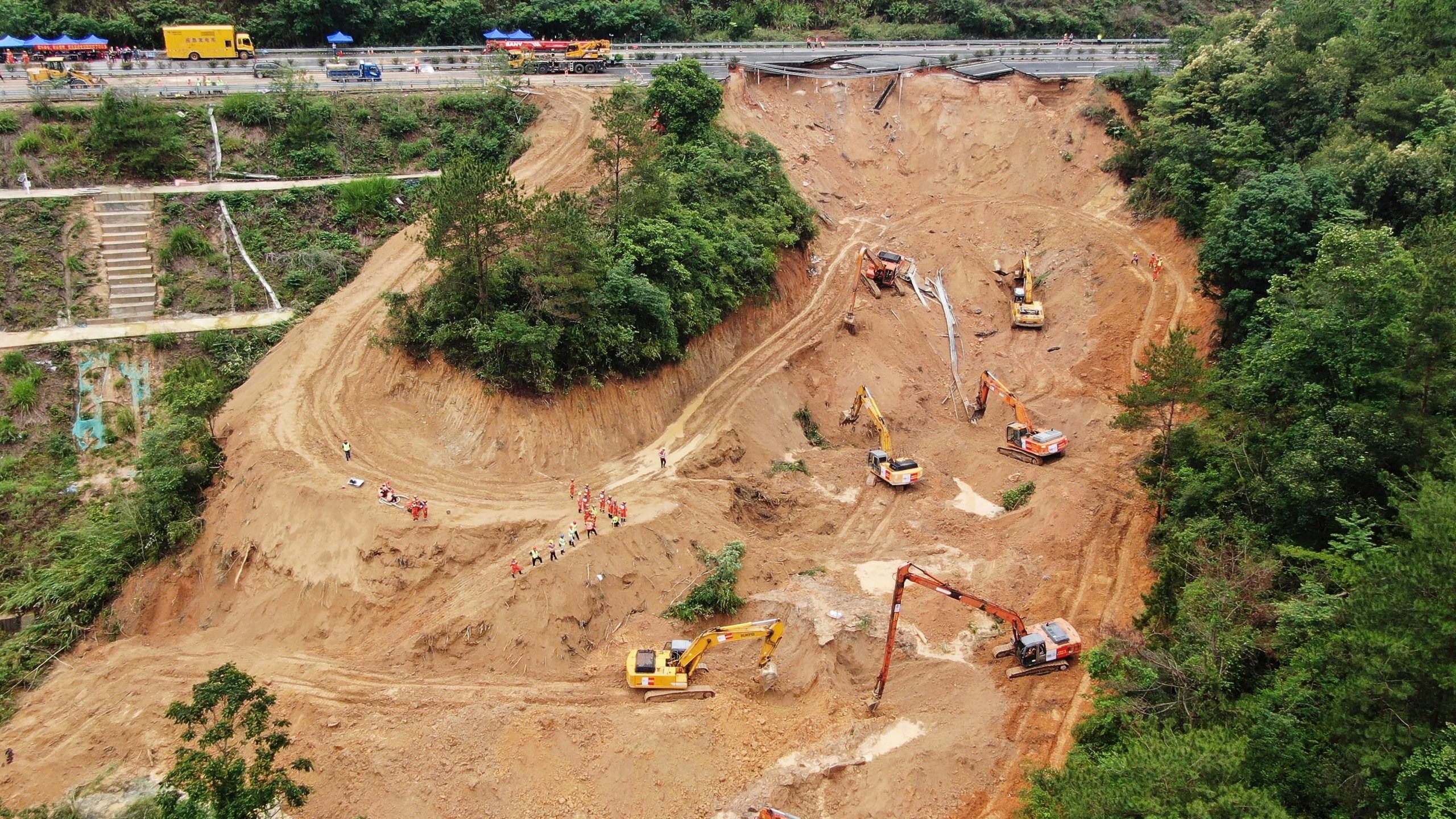 In this photo released by Xinhua News Agency, an aerial drone photo taken on May 2, 2024 shows rescuers and excavators working at the site of a highway section that collapsed on the Meizhou-Dabu Expressway in Meizhou, south China's Guangdong Province. The death toll has climbed as search efforts continue in southern China after a highway section collapsed in a mountainous area, sending more a dozen cars down a steep slope. (Wang Ruiping/Xinhua via AP)