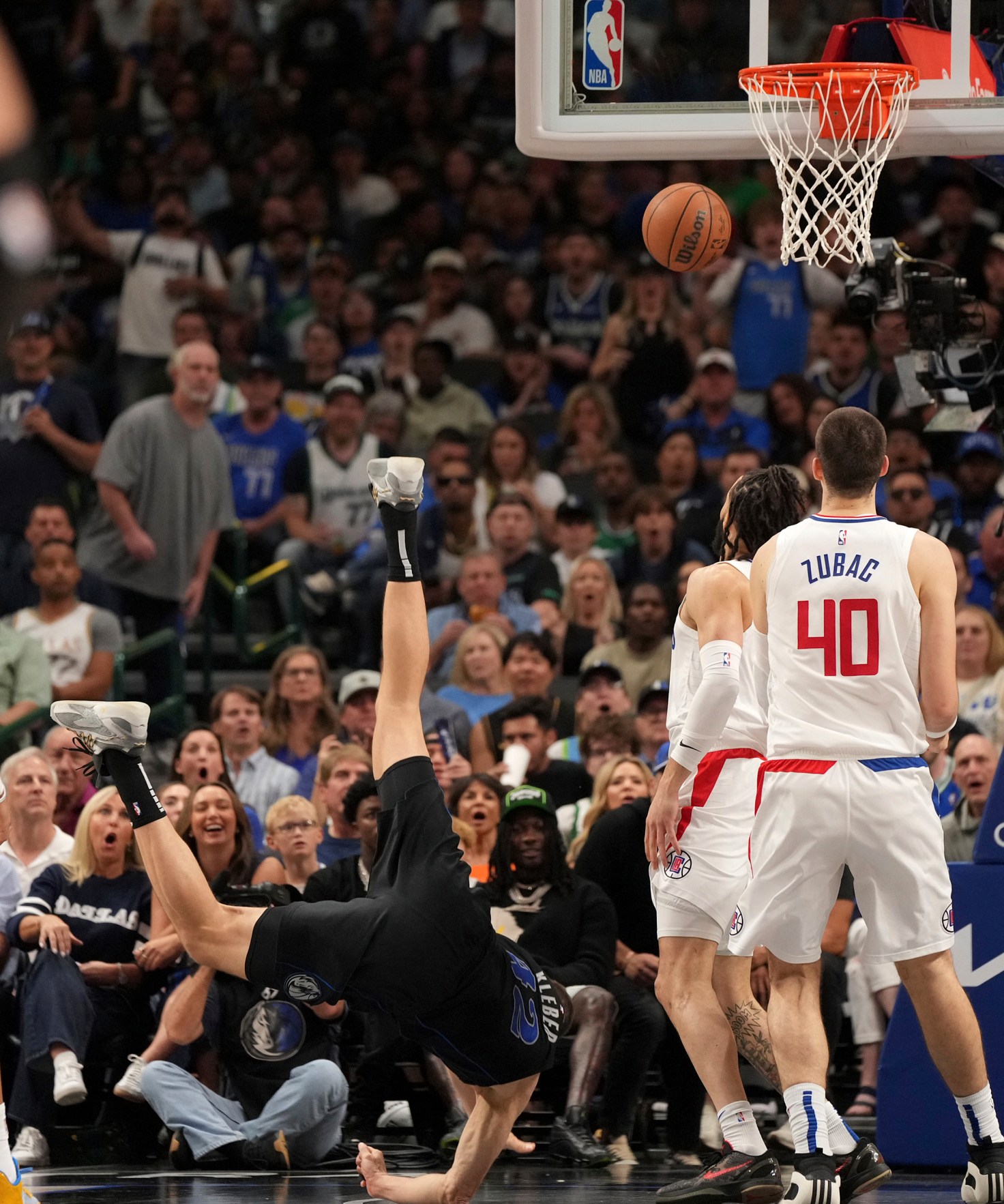 Dallas Mavericks forward Maxi Kleber (42) crashes to the floor after being upended in front of Los Angeles Clippers center Ivica Zubac (40) and guard Amir Coffey during the first half of Game 6 of an NBA basketball first-round playoff series Friday, May 3, 2024, in Dallas. (AP Photo/Jeffrey McWhorter)