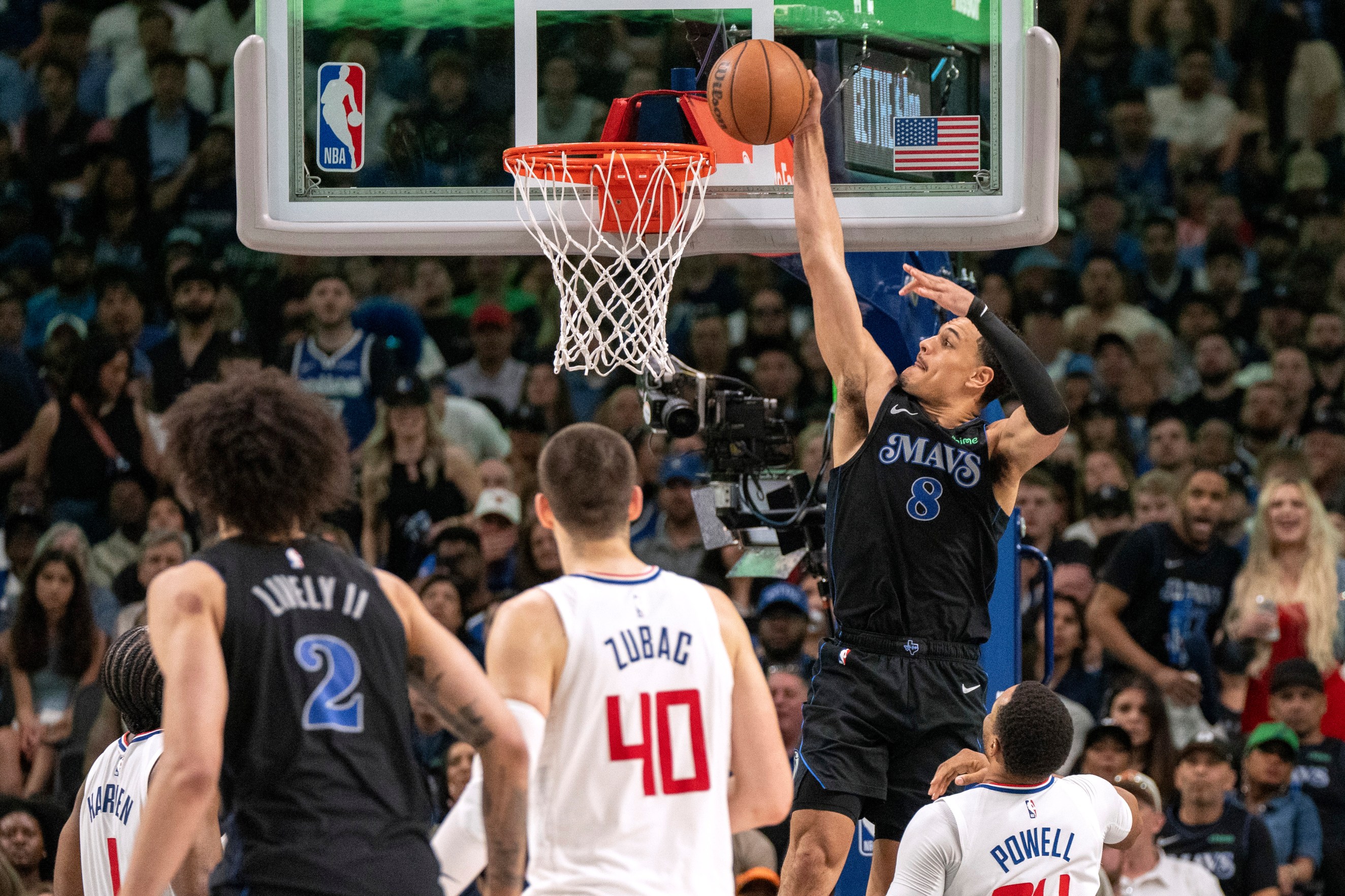 Dallas Mavericks guard Josh Green (8) slam dunks an alley oop from Mavericks' guard Luka Doncic, not pictured, over Los Angeles Clippers guard Norman Powell (24) as Clippers' center Ivica Zubac (40) and Mavericks' center Dereck Lively II (2) look on during the first half of Game 6 of an NBA basketball first-round playoff series Friday, May 3, 2024, in Dallas. (AP Photo/Jeffrey McWhorter)