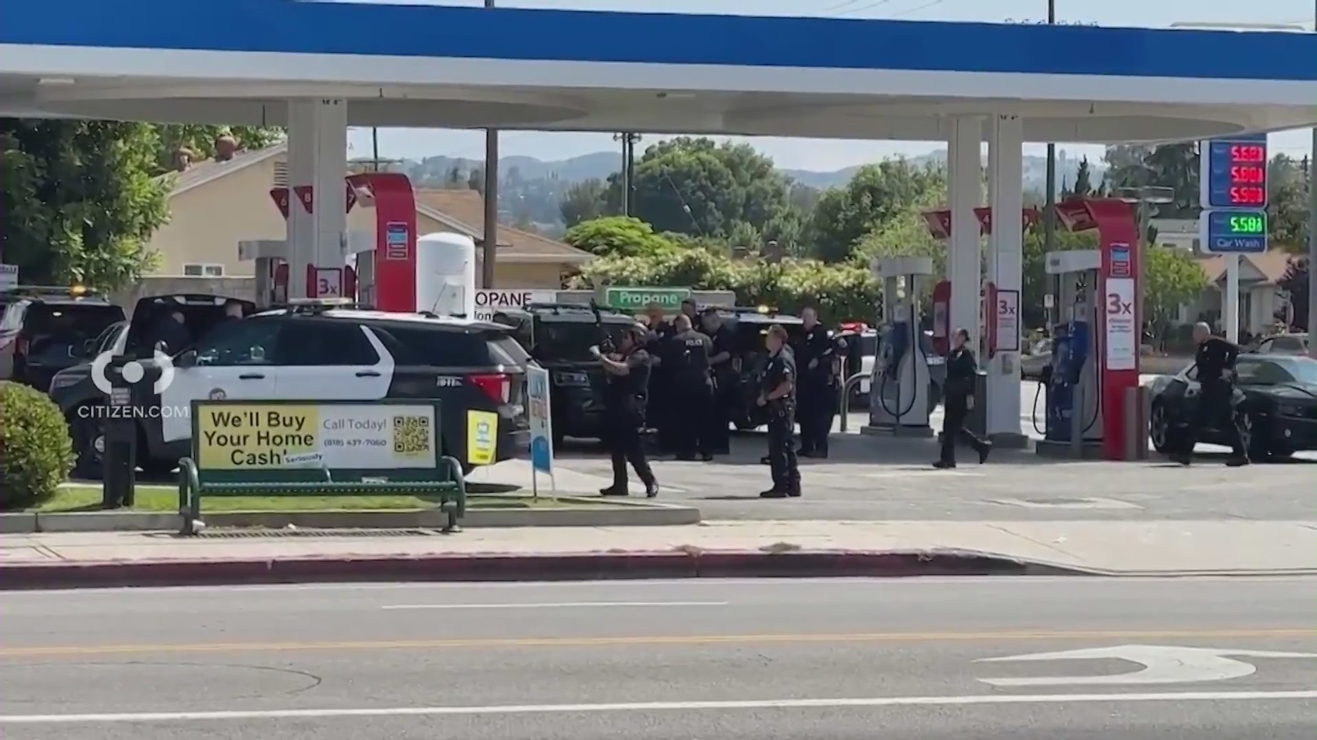 Police and SWAT Team members set up at a gas station near a Tarzana home where a shooting suspect was barricaded inside on May 18, 2024. (Citizen)