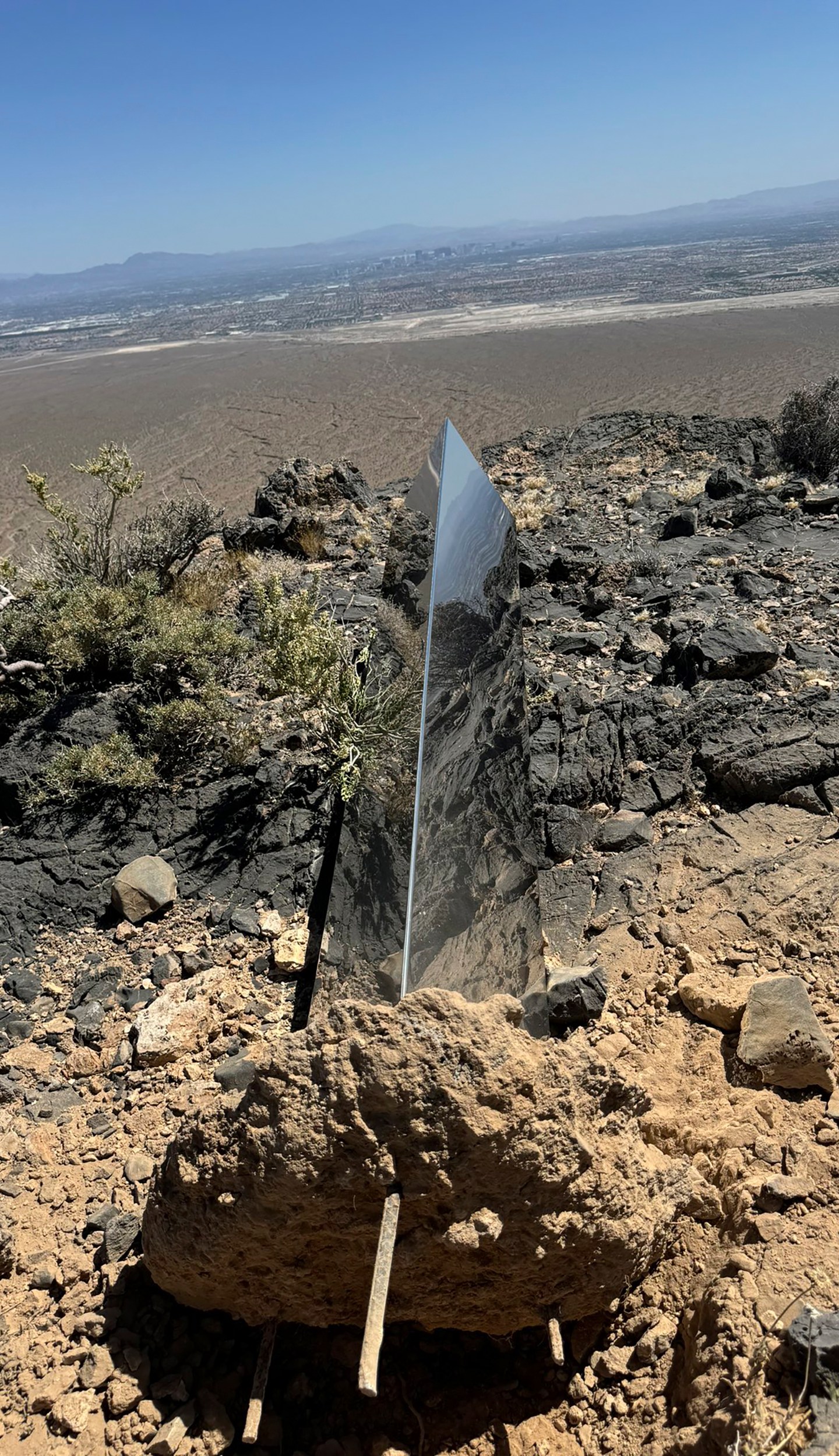 This photo provided by Las Vegas Metropolitan Police Department, the mysterious Monolith is removed on Thursday, June 20, 2024 in Gass Peak, part of the vast Desert National Wildlife Refuge in Nevada. A strange monolith found jutting out of the rocks in a remote mountain range near Las Vegas has been taken down by authorities. (Las Vegas Metropolitan Police Department via AP)