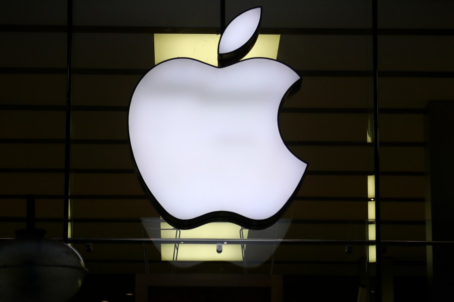FILE - The logo of Apple is illuminated at a store in the city center in Munich, Germany, on Dec. 16, 2020. European Union regulators have accused Apple of breaking new rules on digital competition by preventing software developers on its App Store from steering users to other venues. (AP Photo/Matthias Schrader, File)