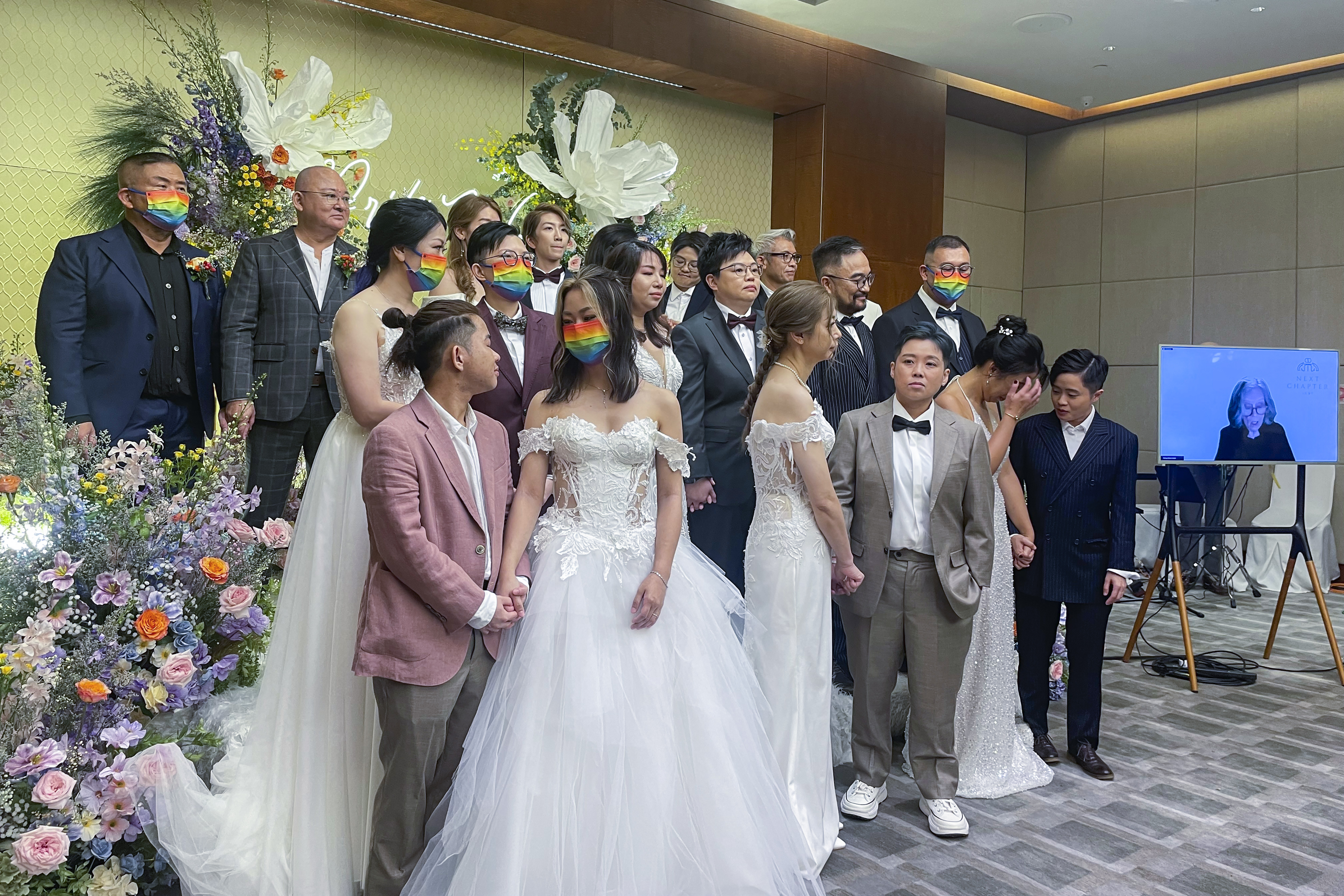 Ten same-sex couples who got married in the United States over the internet stand during their wedding at Eaton Hotel, Kowloon, Hong Kong, Tuesday, June 25, 2024. The semi-autonomous southern Chinese city does not formally recognize such unions but offers them legal protections. The event Tuesday was timed to mark Pride Month. (AP Photo/Alice Fung)