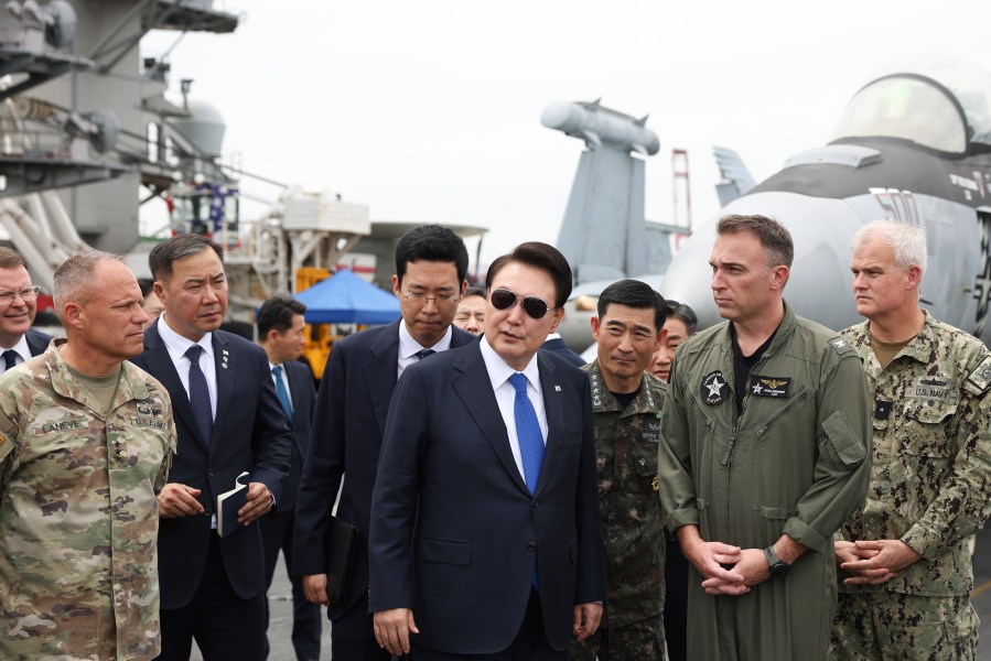 South Korean President Yoon Suk Yeol, center, boards the USS Theodore Roosevelt aircraft carrier at the South Korean naval base in Busan, South Korea, Tuesday, June 25, 2024 (South Korean Presidential Office/Yonhap via AP)