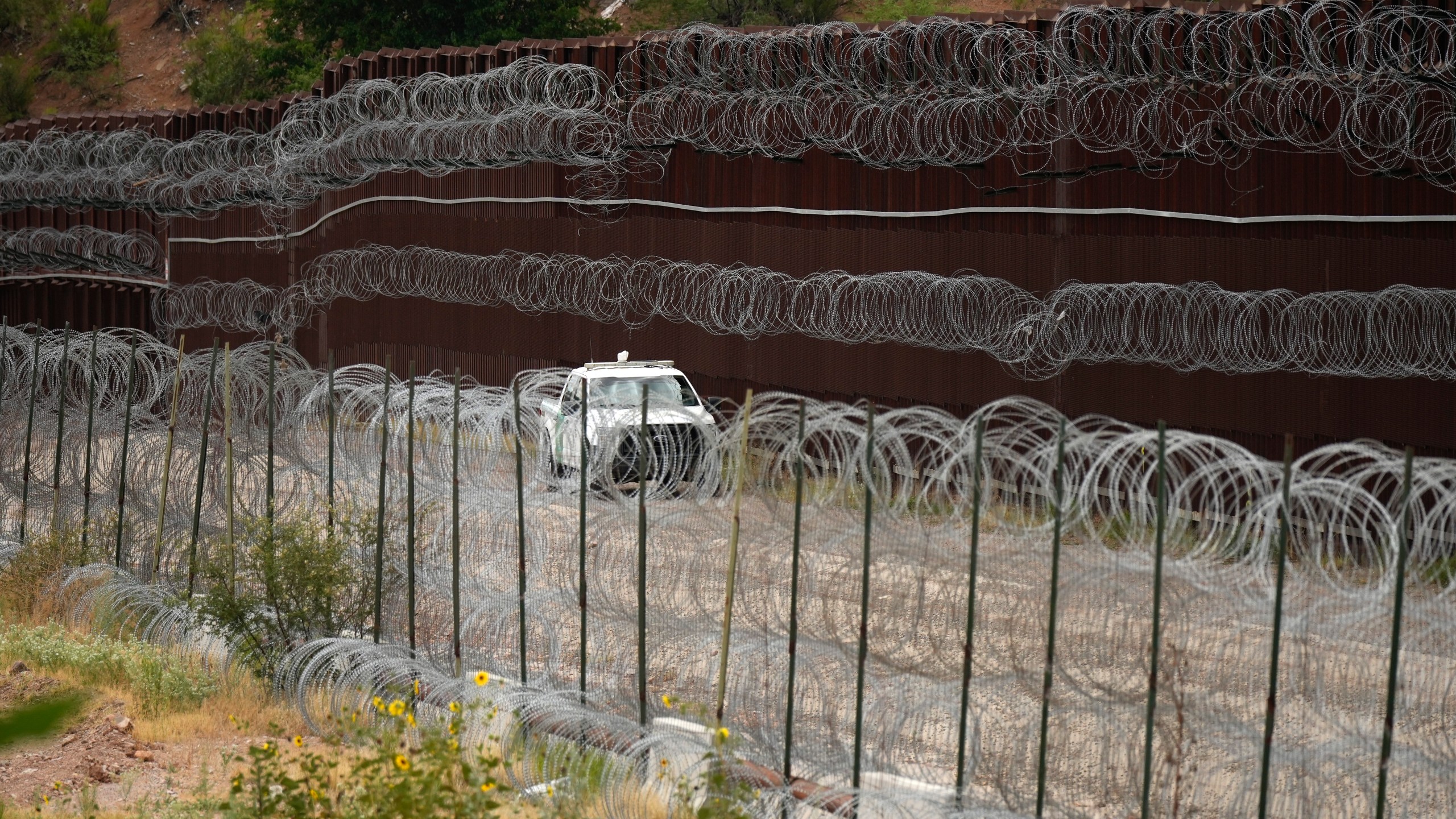 A vehicle drives along the U.S. side of the US-Mexico border wall in Nogales, Ariz. on Tuesday, June 25, 2024. (AP Photo/Jae C. Hong, Pool)