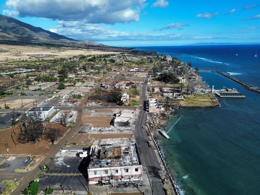 A general view of Front Street shows the primary debris from last year's wildfire being removed for commercial properties, Wednesday, June 26, 2024, in Lahaina, Hawaii. (AP Photo/Mengshin Lin)