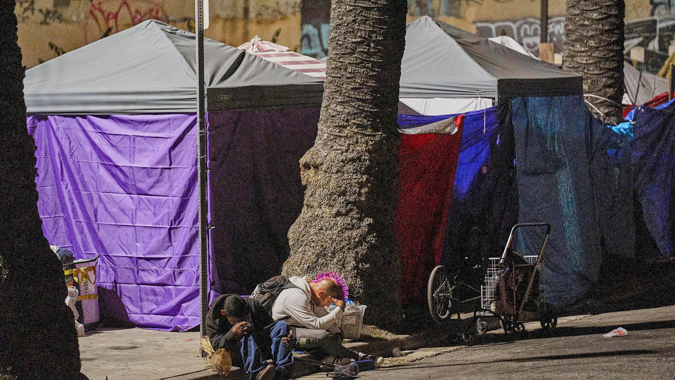 People sleep outside their tents set on the sidewalk early morning Wednesday, June 26, 2024 in the West Lake area of Los Angeles. The number of homeless residents counted in Los Angeles County has dipped slightly, decreasing by about 0.3% since last year as California continues to struggle with the long-running crisis of tens of thousands of people sleeping in cars and encampments. (AP Photo/Damian Dovarganes)