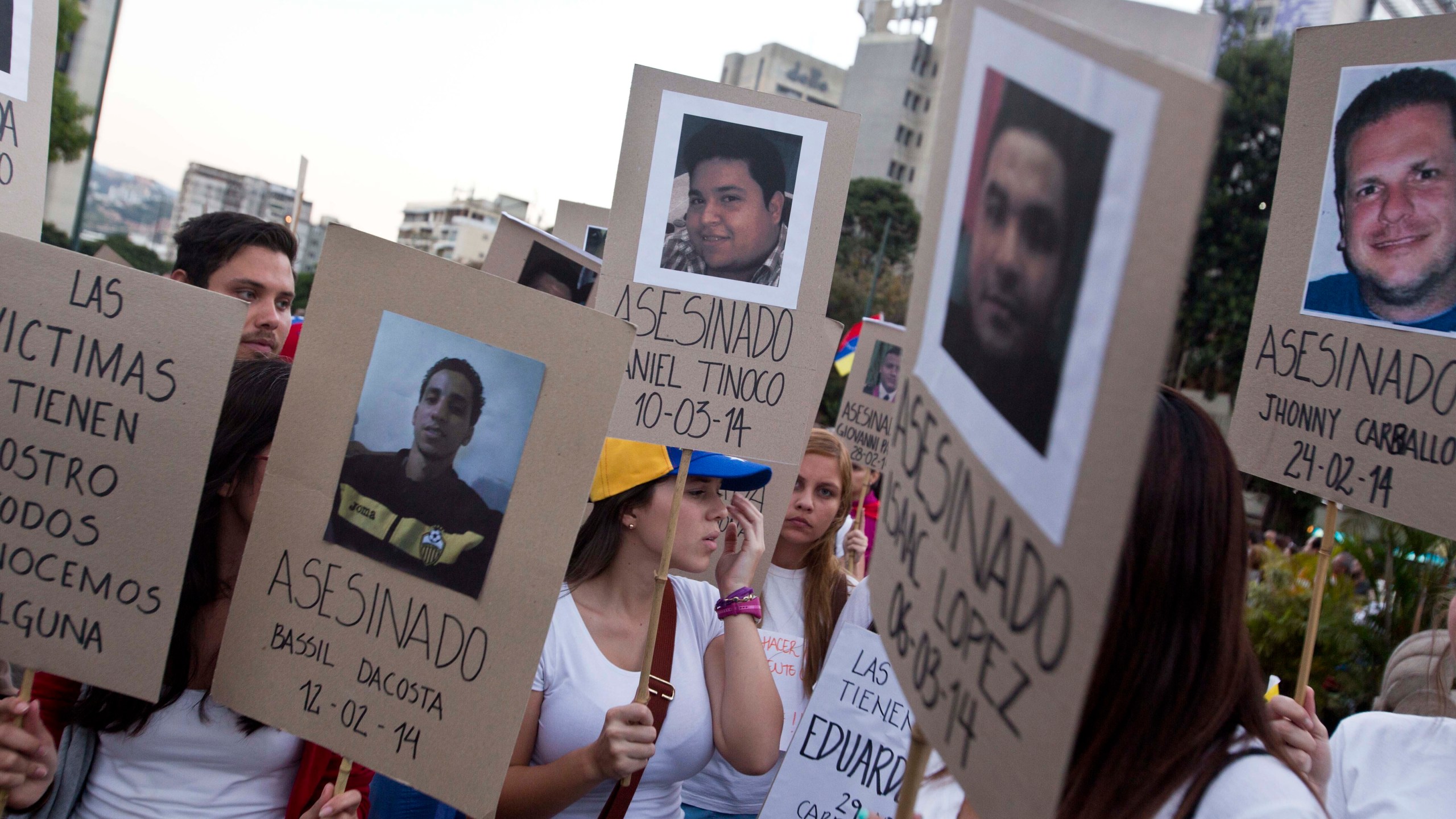 FILE - Demonstrators holds cardboard posters showing images of family and friends killed during anti-government protests, in Caracas, Venezuela, March 18, 2014. An Argentine federal court in Buenos Aires on June 28, 2024, concluded testimony from Venezuelan victims as part of an investigation into probable human rights abuses allegedly committed by security forces during the 2014 clampdown on mass anti-government protests. (AP Photo/Esteban Felix, File)