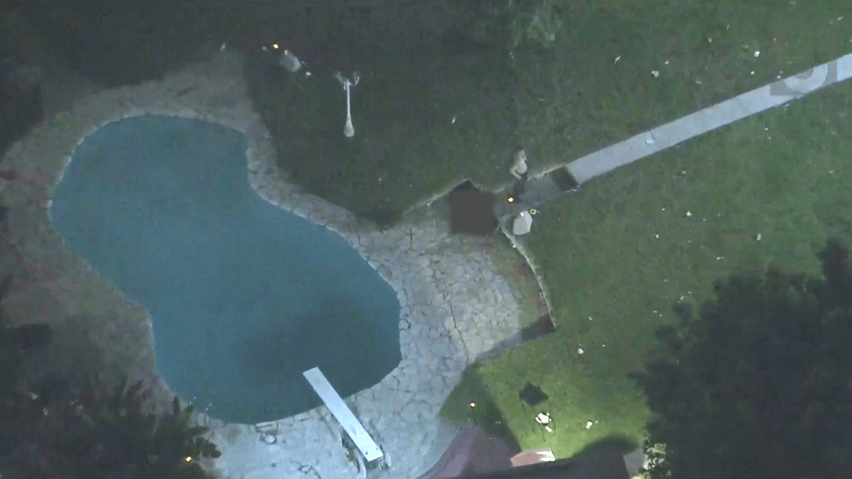 Sky5 footage of a backyard where a body was seen near the pool of a Compton home following a shooting on June 7, 2024. (KTLA)