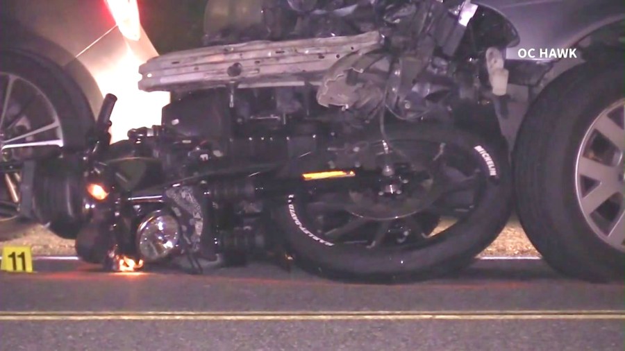 A motorcycle is seen wedged underneath a car after a fatal crash involving a suspected DUI driver in Fullerton on June 12, 2024. (OC Hawk)