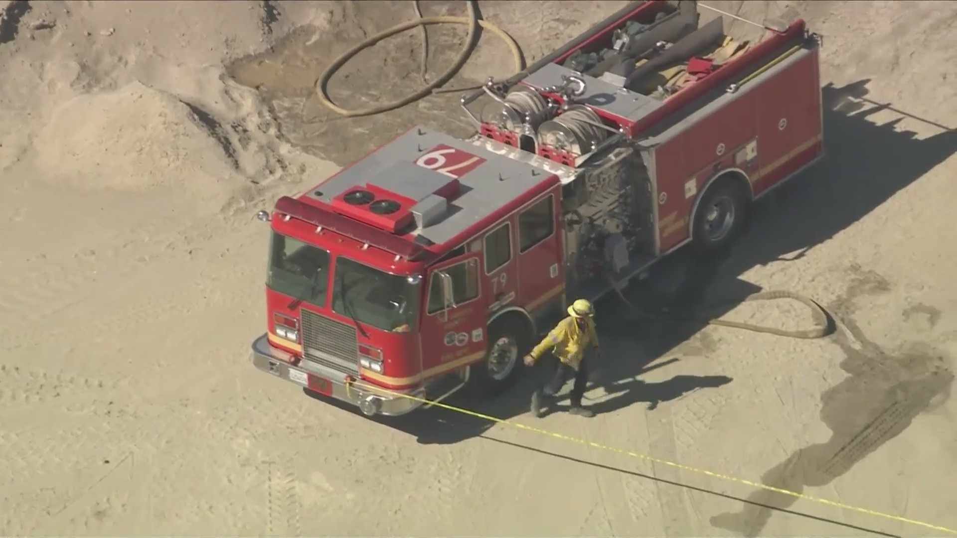 Firefighters work to extinguish the burning tractor vehicle after a ddeadly explosion near Palmdale on June 14, 2024. (KTLA)