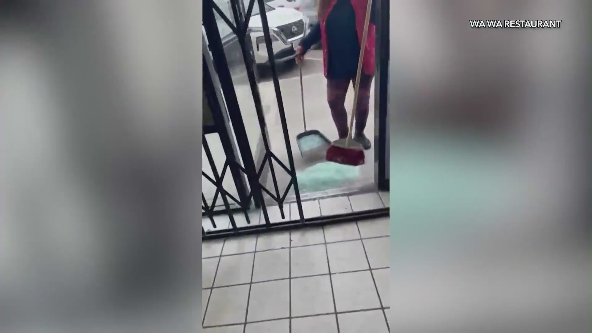 The owners of Wa Wa Restaurant were seen sweeping up a large pile of broken glass after a man smashed their windows on June 6, 2024. (Wa Wa Restaurant)