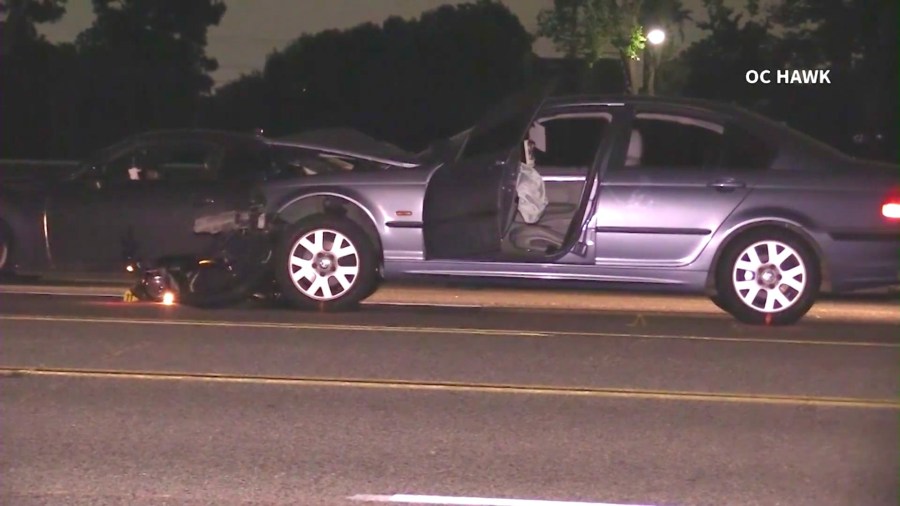 A motorcycle is seen wedged underneath a car after a fatal crash involving a suspected DUI driver in Fullerton on June 12, 2024. (OC Hawk)