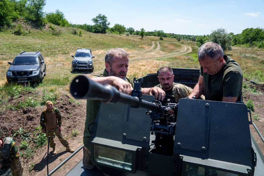 A Ukrainian servicemen aka "Kherson",center, deputy commander of Arey Battalion prepares a machine gun during training at the polygon, in the Dnipropetrovsk region, Ukraine, Saturday, June 22, 2024. Ukraine is expanding its military recruiting to cope with battlefield shortages more than two years into fighting Russia’s full-scale invasion. (AP Photo/Evgeniy Maloletka)