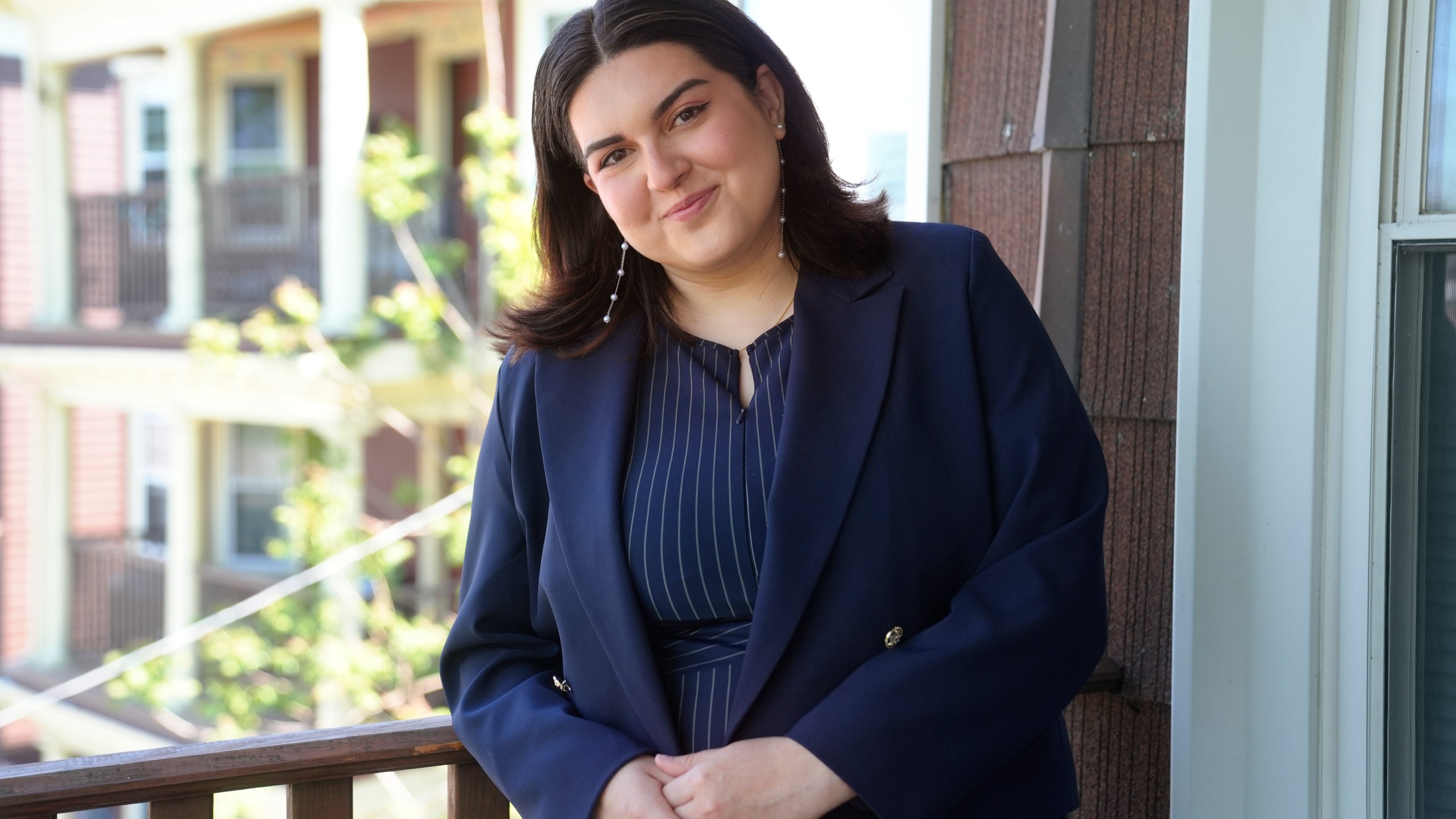 Daniella López White, of Hawaii, poses for a photo on Tuesday, May 14, 2024, on the porch of her apartment, in Boston. López White, who graduated from Emerson College in Boston this month and is on a tight budget, said TikTok influencers have helped her with tips on how to find affordable clothes at places like H&M and thrift shops. (AP Photo/Steven Senne)