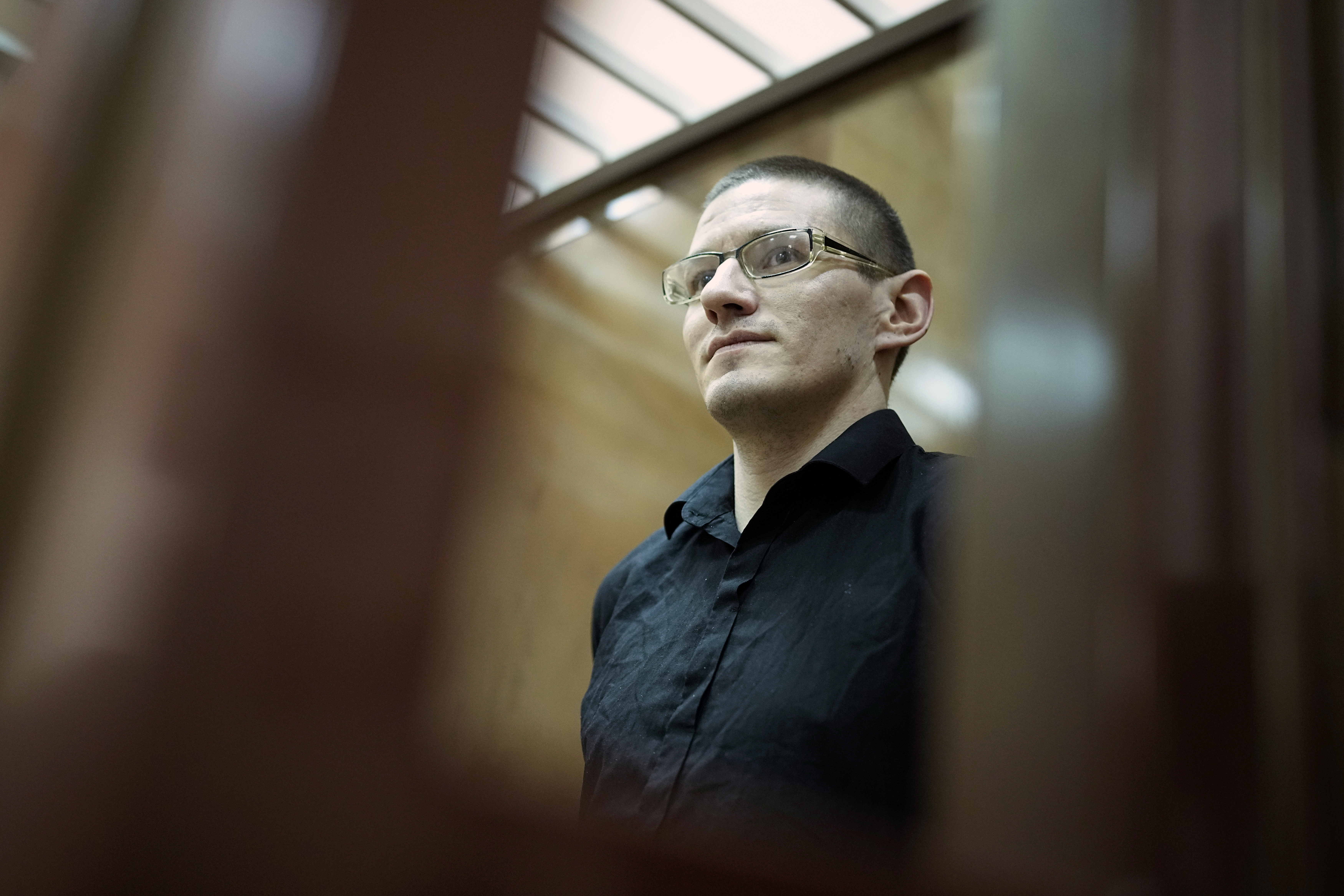 Robert Woodland, a Russia-born U.S. citizen, stands in a glass cage prior to a court hearing, Thursday, July 4, 2024, in Moscow, Russia. Woodland was convicted of drug-related charges and sentenced to 12 and a 1/2 years in prison on Thursday. (AP Photo/Alexander Zemlianichenko)