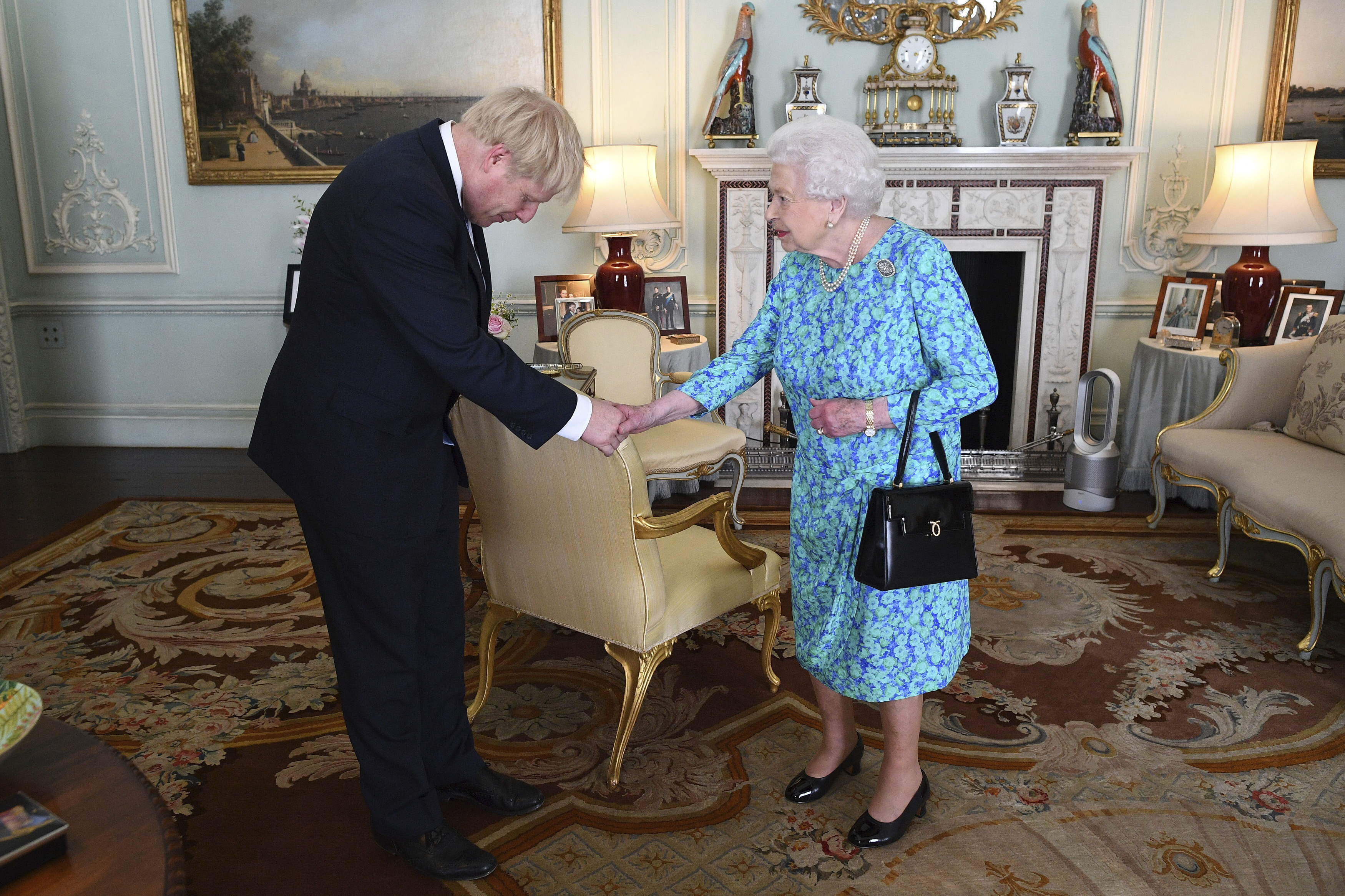 FILE - Britain's Queen Elizabeth II welcomes newly elected leader of the Conservative party Boris Johnson during an audience at Buckingham Palace, London, on July 24, 2019, where she invited him to become prime minister and form a new government. (Victoria Jones/Pool via AP, File)
