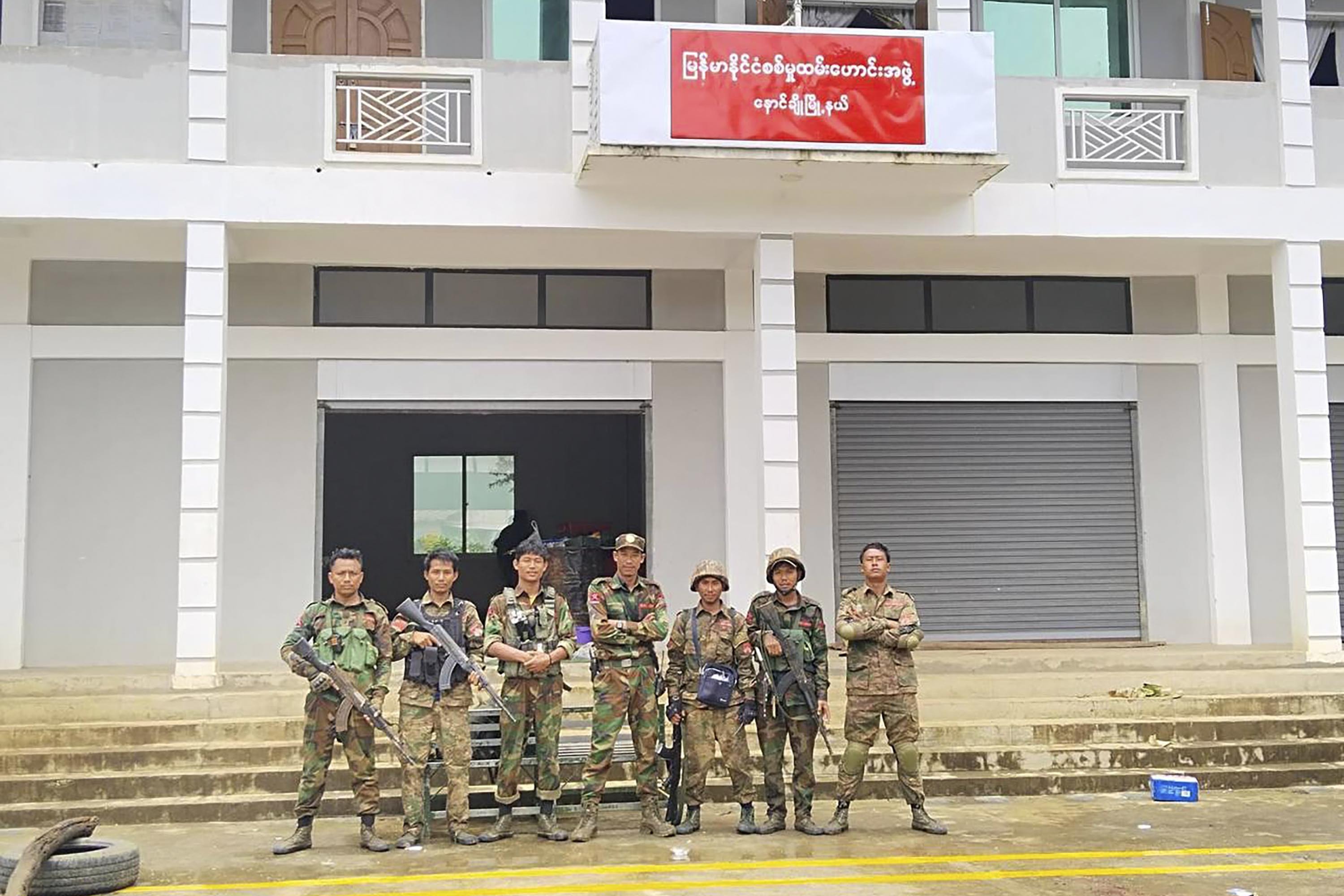 In this handout photo provided by Mandalay People's Defence Force, members of the Ta'ang National Liberation Army, one of the ethnic armed forces in the Brotherhood Alliance, and the Mandalay People's Defence Force pose for a photograph in front of the captured building of the Myanmar War Veterans' Organisation in Nawnghkio township in Shan state, Myanmar, June 26, 2024. New fighting has broken out in northeastern Myanmar, bringing an end to a Chinese-brokered cease-fire and putting pressure on the military regime as it faces attacks from resistance forces on multiple fronts in the country's civil war. (Mandalay People's Defence Force via AP)