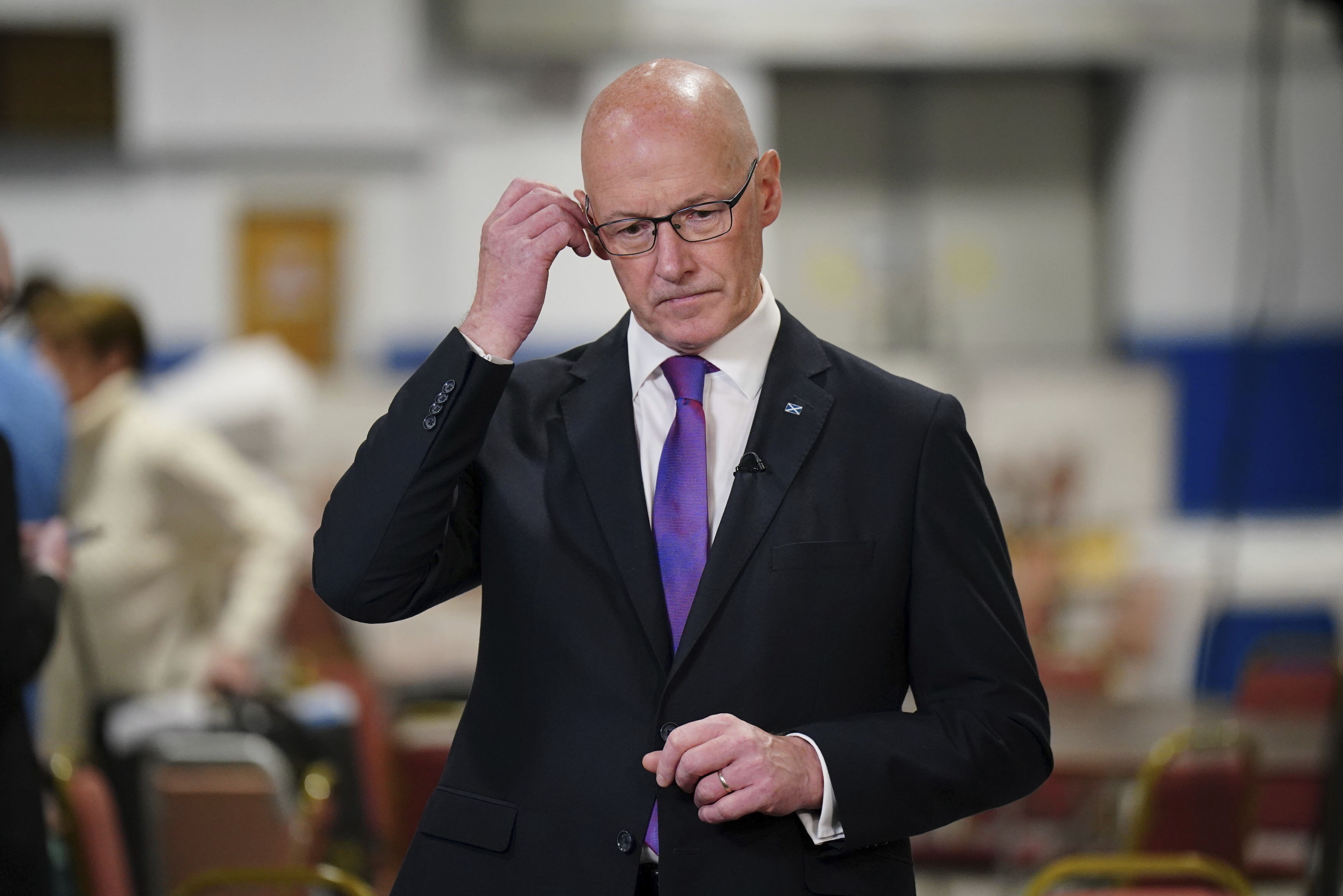 Scottish First Minister and SNP leader John Swinney adjusts his ear piece at Ice Hall in the Dewars Centre, Perth, during the count in the 2024 General Election, Friday July 5, 2024. (Jane Barlow/PA via AP)