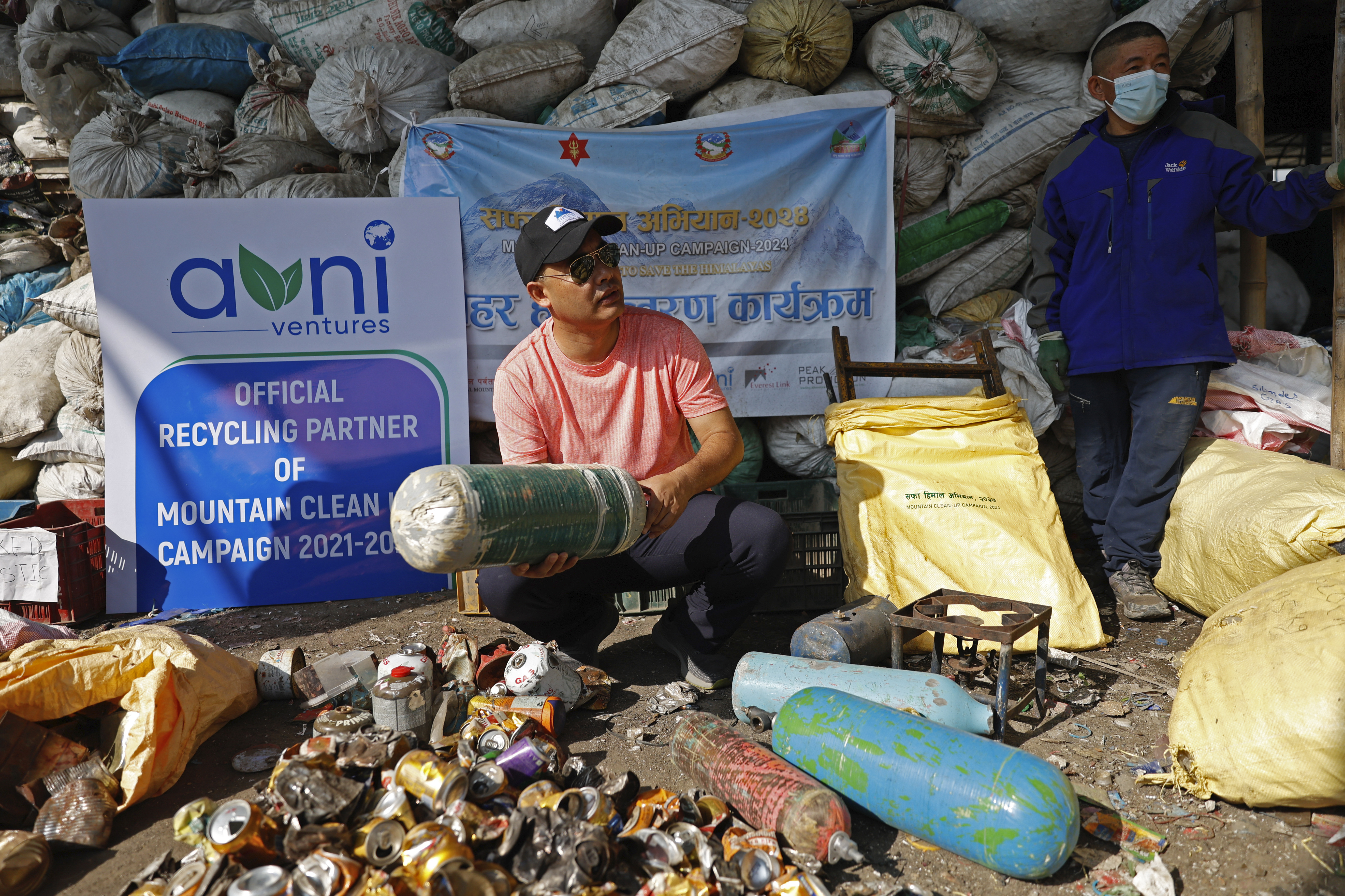 Sushil Khadga of the Agni Ventures, an agency that manages recyclable waste, checks an used oxygen cylinder collected en route Mount Everest before it is recycled at the facility, in Kathmandu, Nepal, Monday, June 24, 2024. The highest camp on the world's tallest mountain is littered with garbage that is going to take years to clean up, according to a Sherpa who led a team that worked to clear trash and dig up dead bodies frozen for years near Mount Everest's peak. (AP Photo/Sanjog Manandhar)