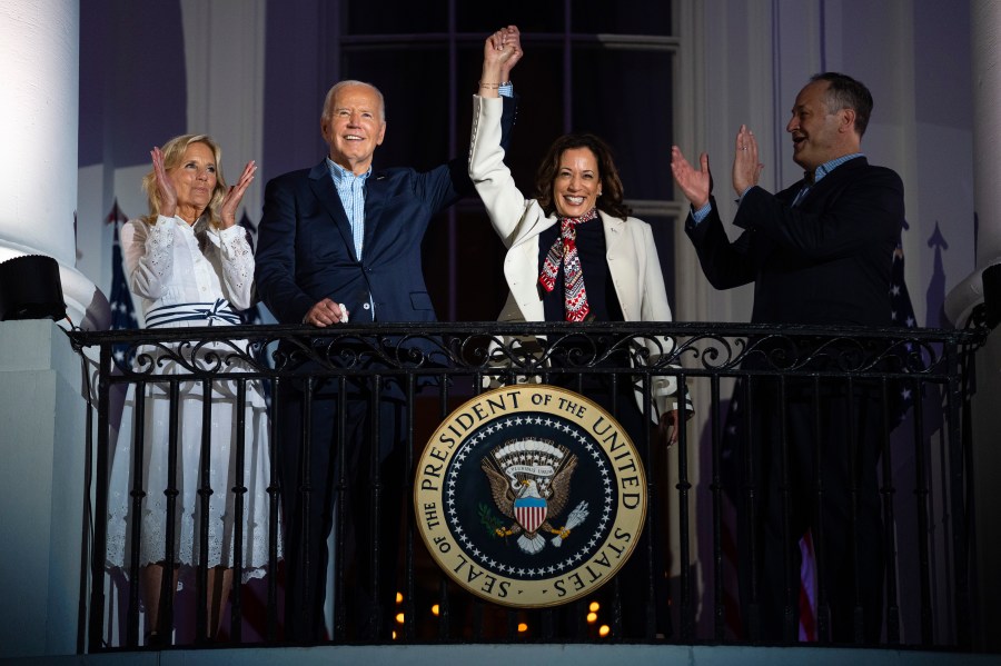 First lady Jill Biden and second gentleman Douglass Emhoff watch as President Joe Biden raises the hand of Vice President Kamala Harris as they view the Independence Day firework display over the National Mall from the balcony of the White House, Thursday, July 4, 2024, in Washington. (AP Photo/Evan Vucci)