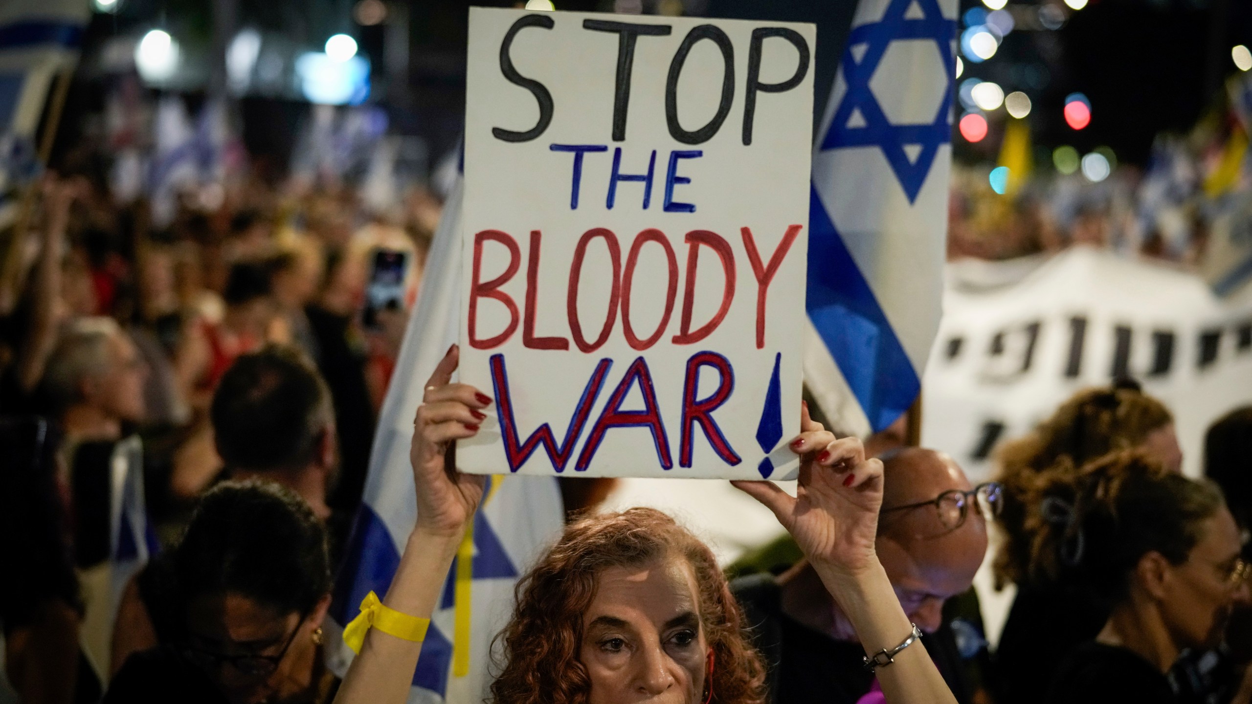 A demonstrator holds a sign during a protest marking nine months since the start of the war and calling for the release of hostages held in the Gaza Strip by the Hamas militant group, in Tel Aviv, Israel, Sunday, July 7, 2024. (AP Photo/Leo Correa)