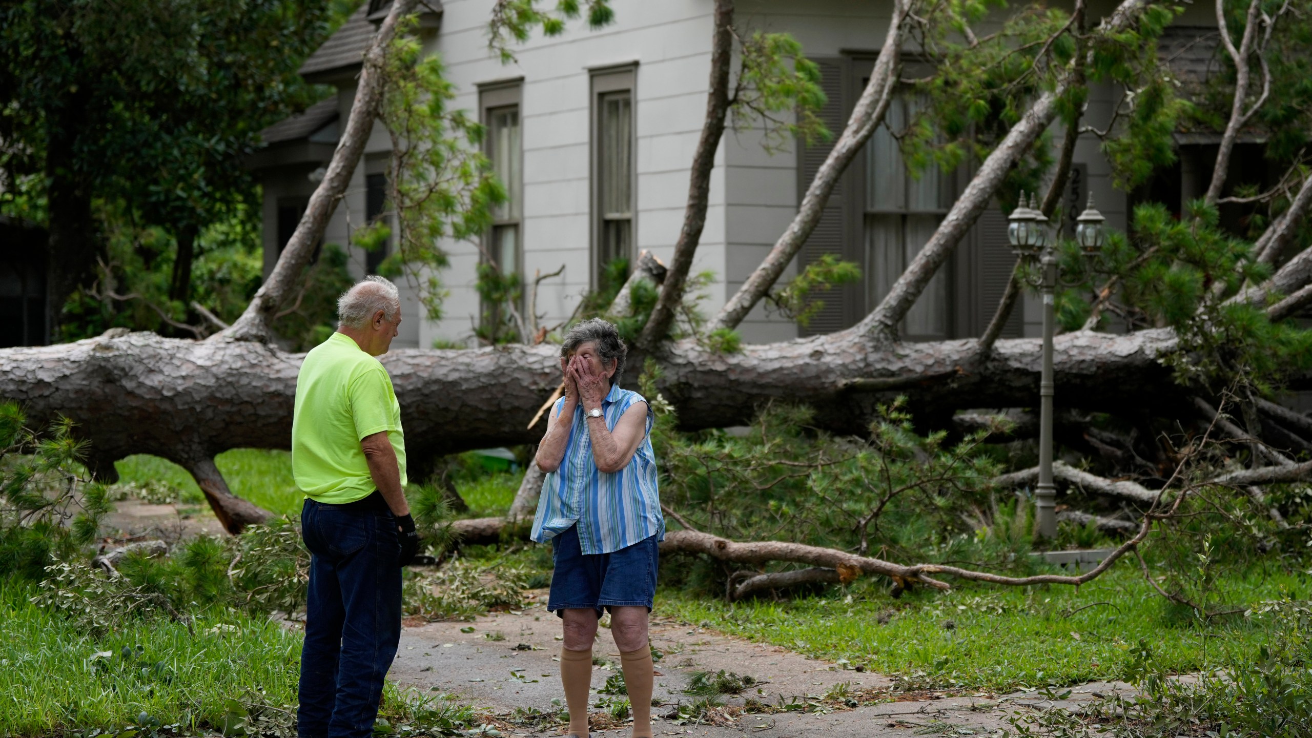 Jackie Jecmenek, right, talks with city worker Bobby Head as she stands in front of her neighbor's home after Beryl passed, Monday, July 8, 2024, in Bay City, Texas. (AP Photo/Eric Gay)