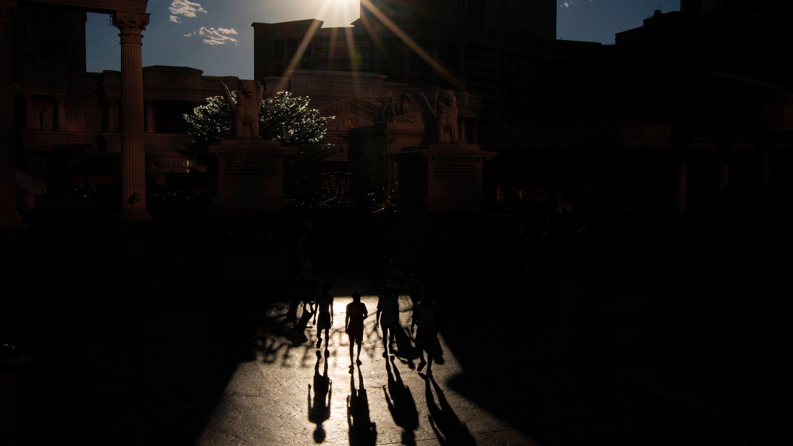 People walk in the sun along the Las Vegas Strip, Sunday, July 7, 2024, in Las Vegas. The city set an all time record high of 120 F (48.8 C) Sunday as a heat wave spread across the Western U.S. sending many residents in search of a cool haven from the dangerously high temperatures. (AP Photo/John Locher)