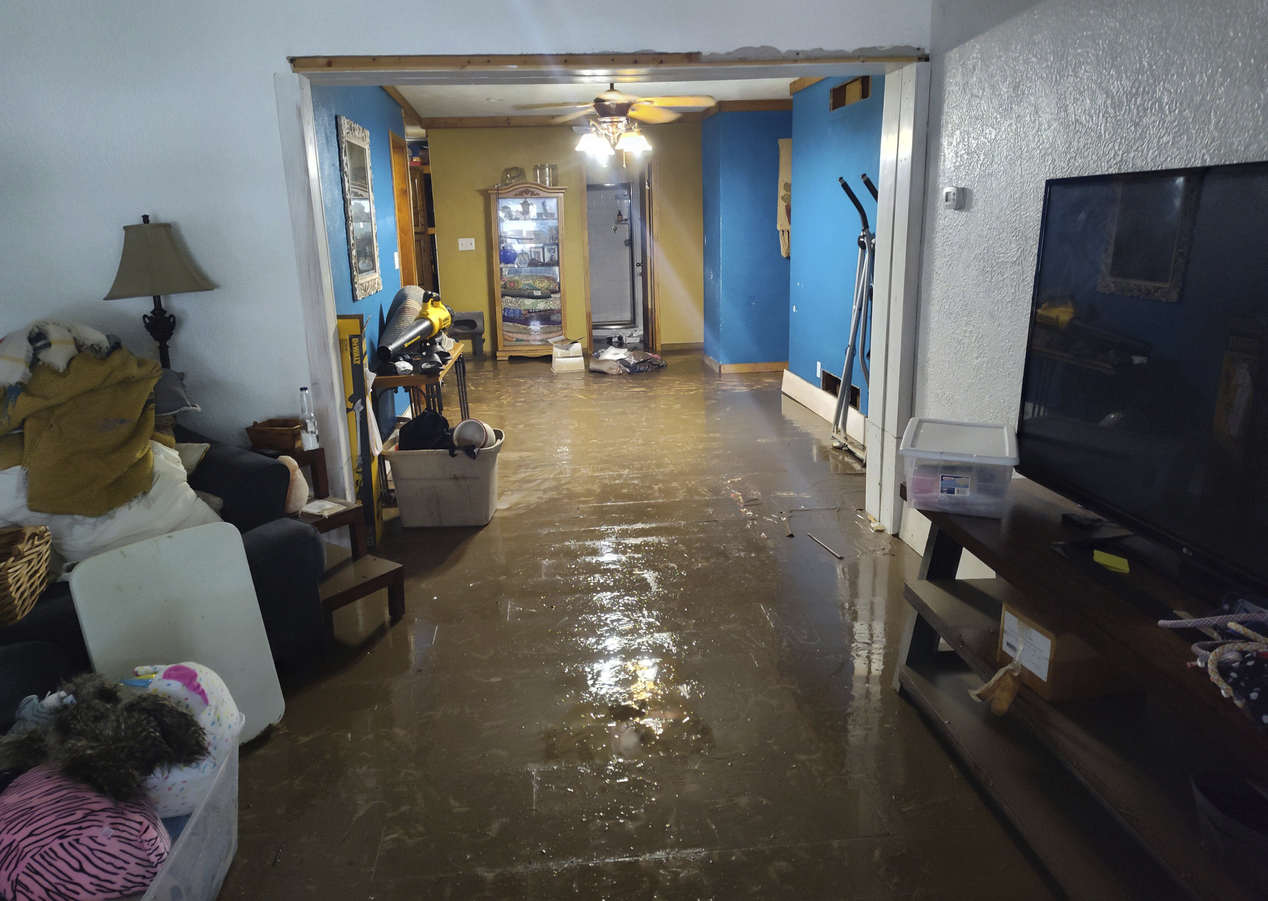 Water and mud coat the floor of Jami Lane's home in Nashville, Ill., after a nearby creek flooded on Tuesday, July 16, 2024. Lane said the floodwaters reached three feet deep on the main floor of the home, and had never previously entered the house in her roughly 20 years of living there. (Ben Gray/St. Louis Post-Dispatch via AP)