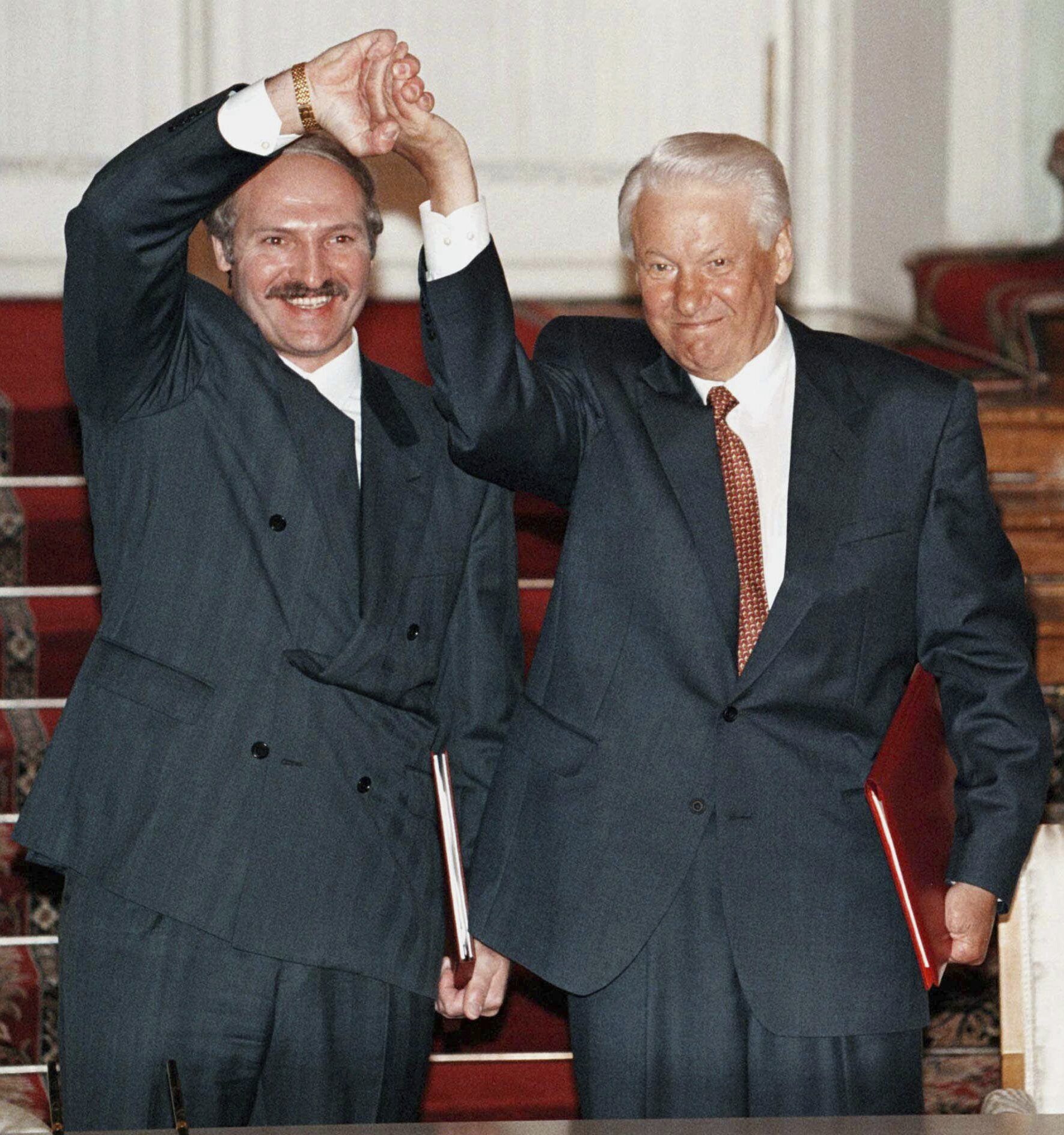 FILE – Russian President Boris Yeltsin and Belarusian President Alexander Lukashenko shake hands after signing a union charter at the Kremlin in Moscow, on May 23, 1997. Lukashenko this week marks 30 years in power. (Vladimir Mashatin/Pool Photo via AP, File)