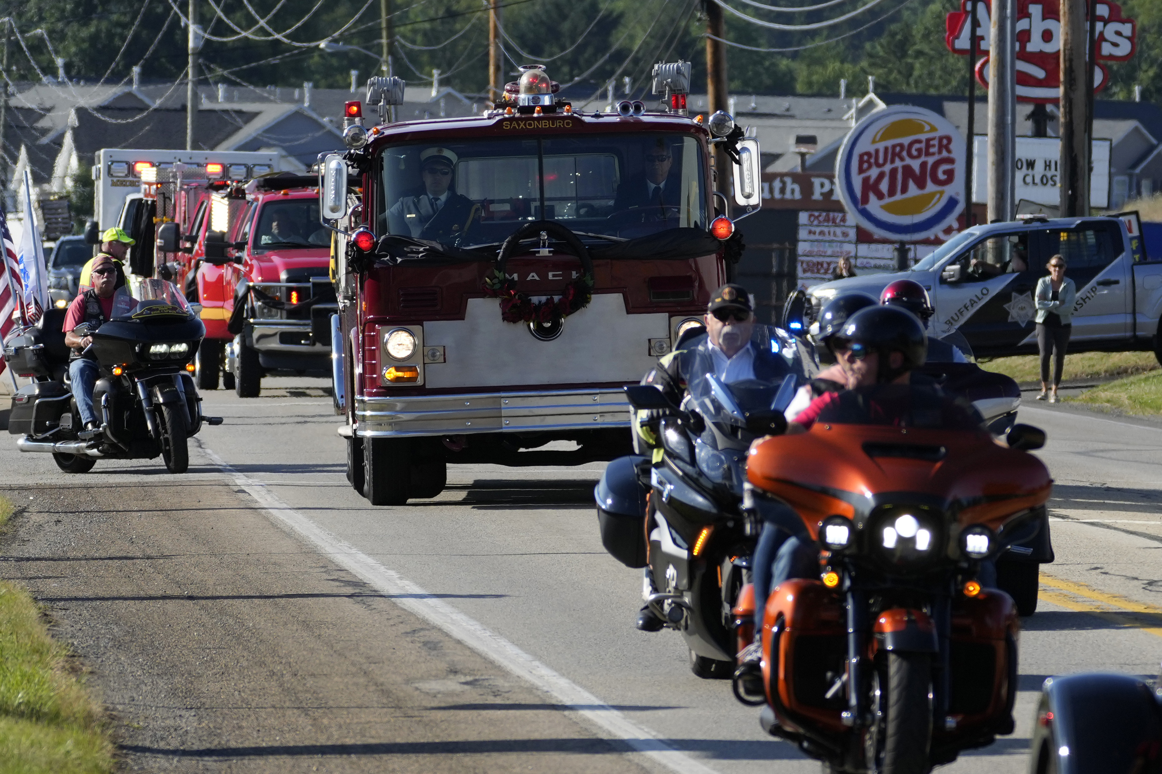The funeral procession for Corey Comperatore passes, Friday, July 19, 2024, in Sarver, Pa. Comperatore, a former fire chief, was shot and killed while attending a weekend rally for former President Donald Trump. (AP Photo/Matt Slocum)