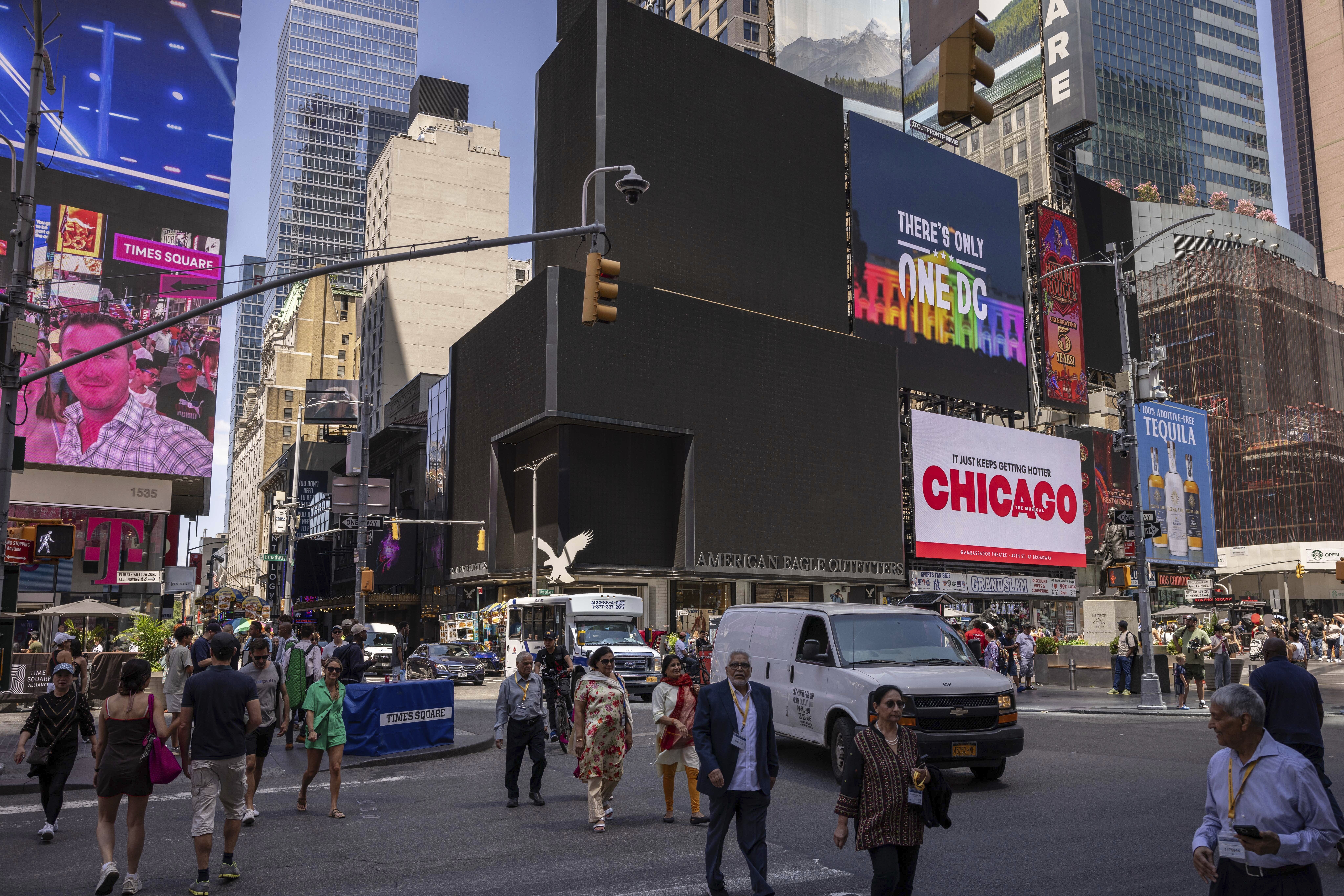 Pedestrians walk by blacked out screens due to a global technology outage, in Times Square, Friday, July 19, 2024, in New York. (AP Photo/Yuki Iwamura)