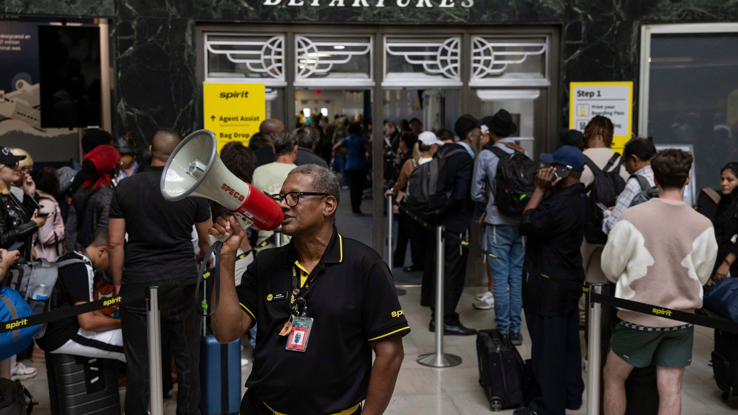 An employee instructs customers at a departure area for Spirit Airlines at LaGuardia Airport in New York on Friday, July 19, 2024, after a faulty CrowdStrike update caused a major internet outage for computers running Microsoft Windows. (AP Photo/Yuki Iwamura)