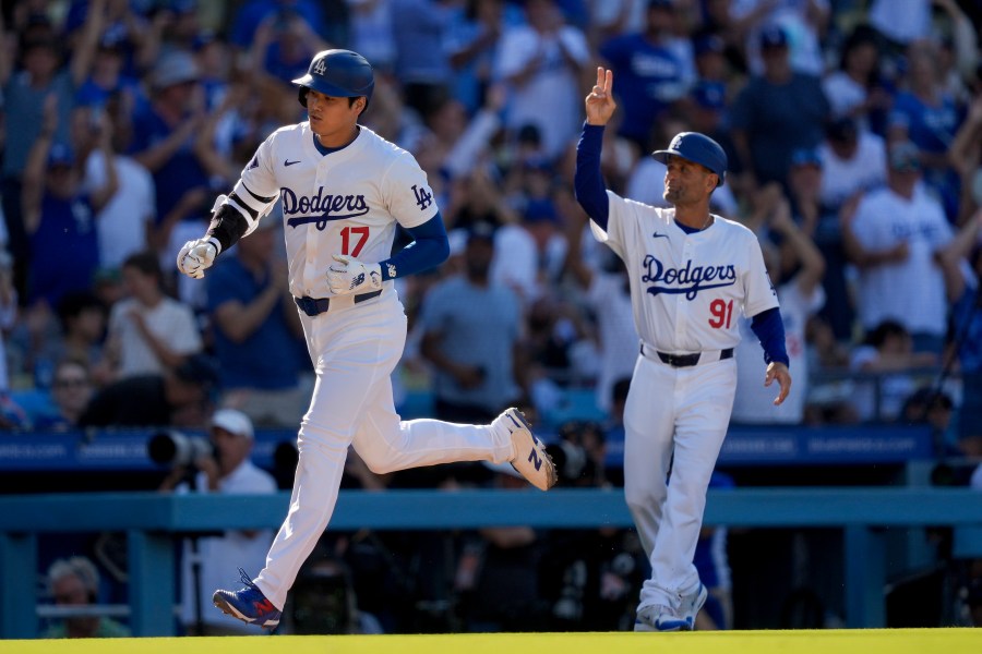 Los Angeles Dodgers designated hitter Shohei Ohtani, left, celebrates his solo home run with third base coach Dino Abel, right, during the fifth inning of a baseball game against the Boston Red Sox, Sunday, July 21, 2024, in Los Angeles. (AP Photo/Ryan Sun)