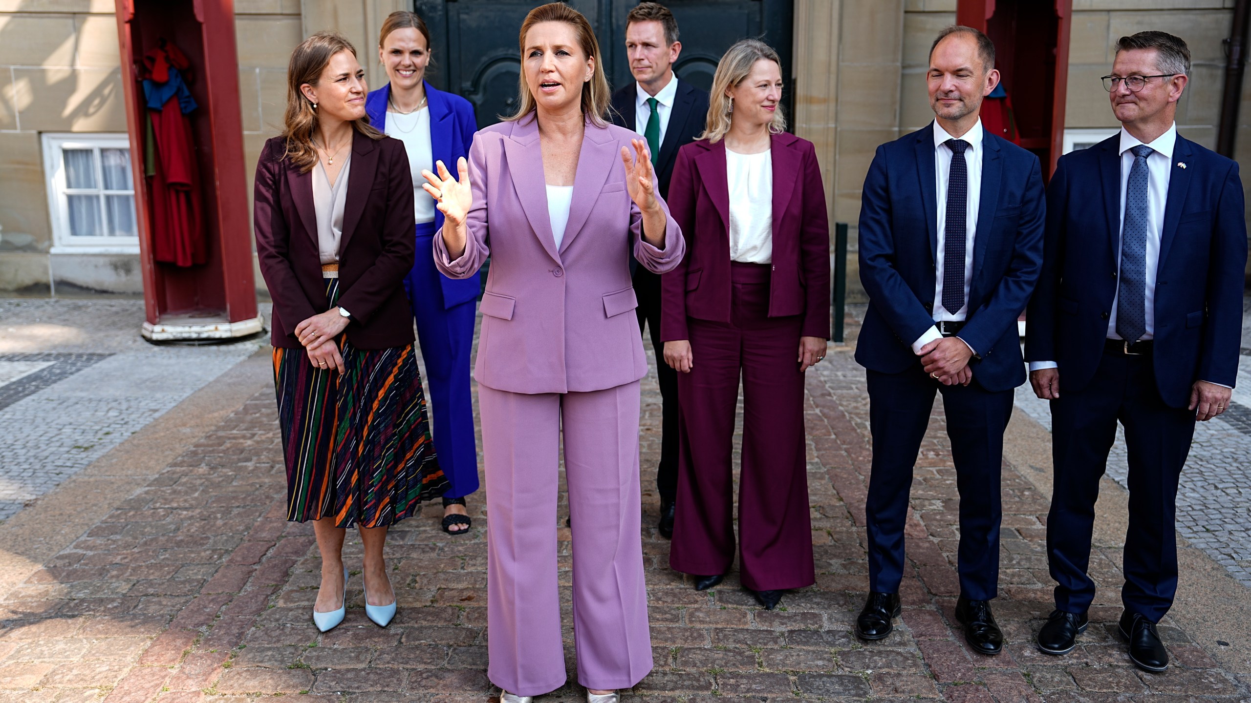 Danish Prime Minister Mette Frederiksen, center, Minister for Community Safety and Preparedness Torsten Schack Pedersen, right, Minister for Green Tripartite Jeppe Bruus, 2nd right, European Minister Marie Bjerre, left, Minister for Digitalisation Caroline Stage Olsen, 2nd left, Tax Minister Rasmus Stoklund, 4th right, and Social and Housing Minister Sophie Haestorp Andersen, 3rd right, are presented as new minister in front of Frederik VIII's Palace, Amalienborg Palace, in Copenhagen, Thursday, Aug. 29, 2024. (Mads Claus Rasmussen/Ritzau Scanpix via AP)