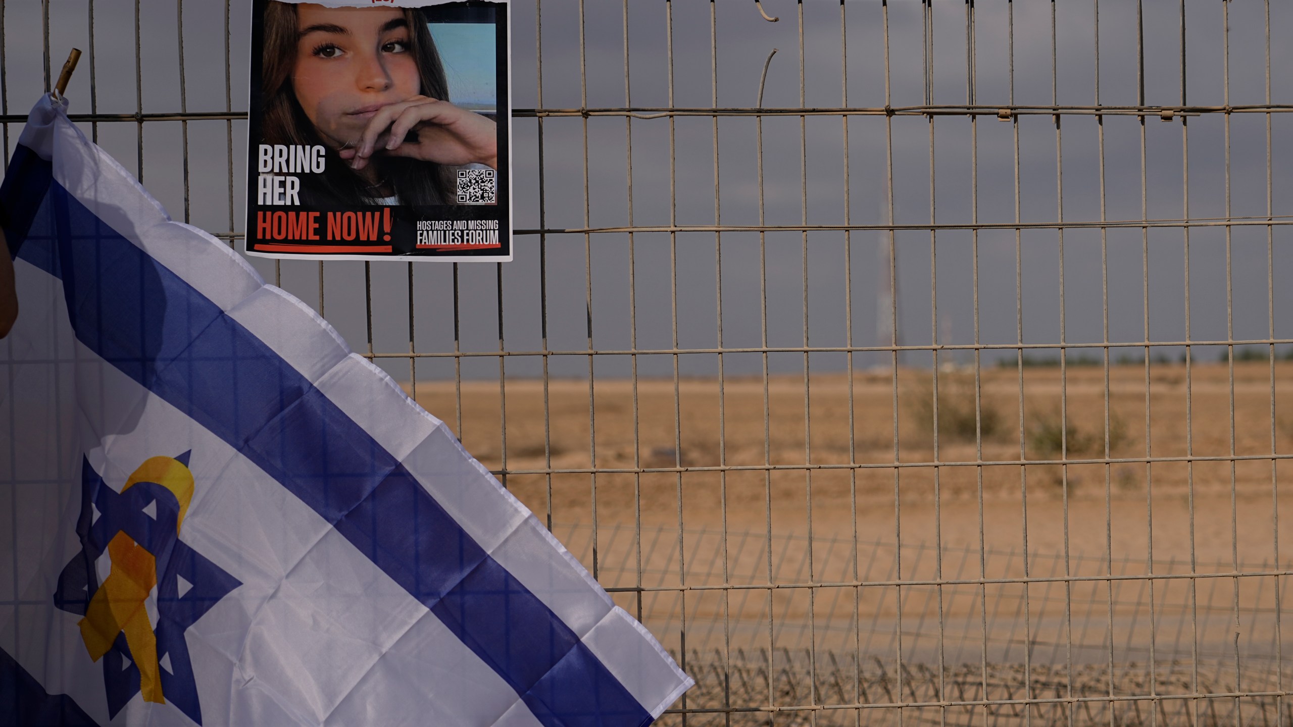 A photo of Agan Berger, who was kidnapped during Hamas militants attack on Oct. 7, hangs on a fence of the kibbutz Nirim as relatives and friends of the hostages held in the Gaza Strip take part in a protest calling for their release in southern Israel, Thursday, Aug. 29, 2024. (AP Photo/Tsafrir Abayov)