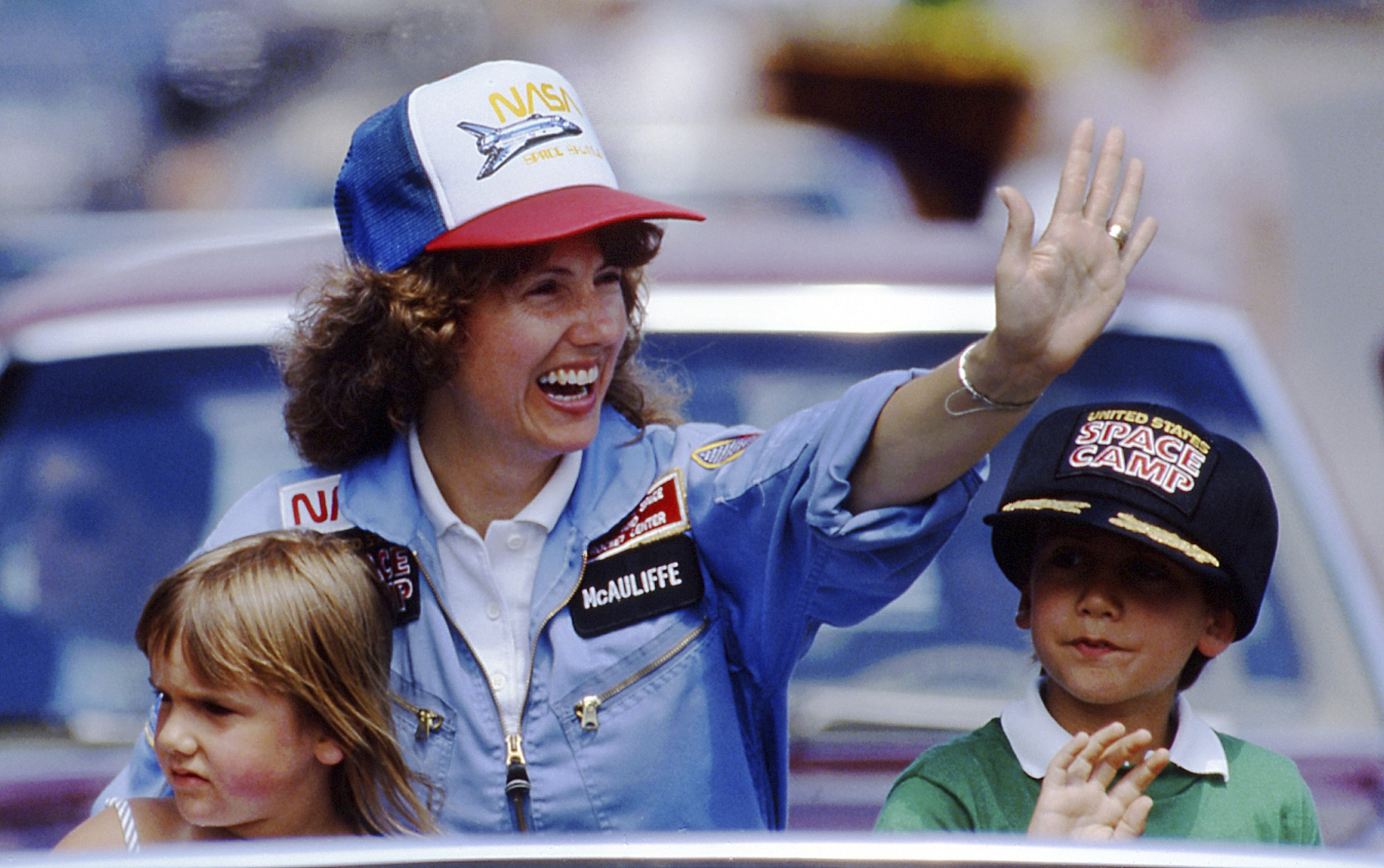 FILE - In this 1985 file photo, high school teacher Christa McAuliffe rides with her children Caroline, left, and Scott during a parade down Main Street in Concord, N.H. (AP Photo/Jim Cole, File)