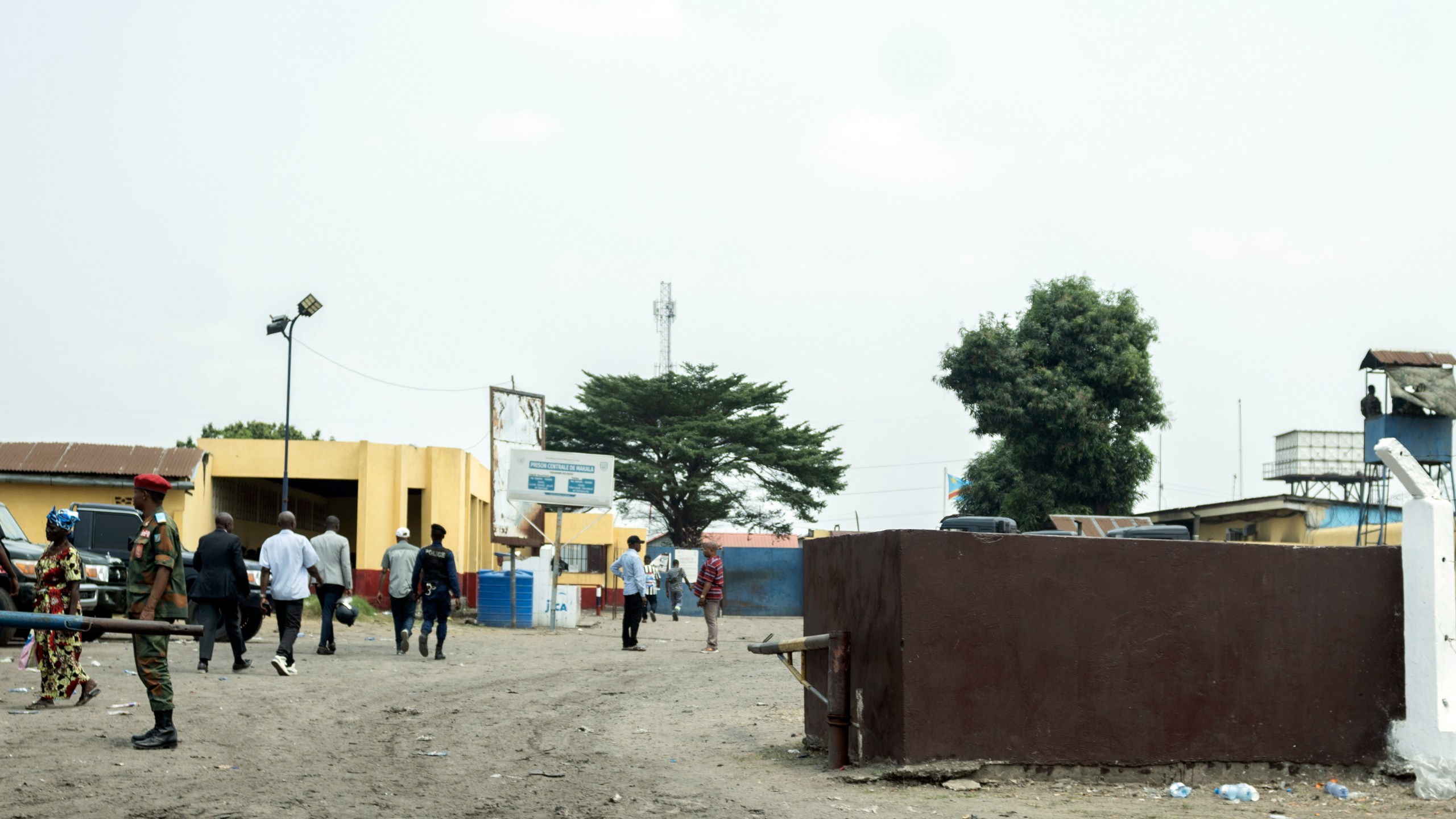 People walk past the Makala Central prison in Kinshasa, Congo, Tuesday, Sept. 3, 2024, after an attempted jailbreak in Congo’s main prison that left many people dead. (AP Photo/Samy Ntumba Shambuyi)