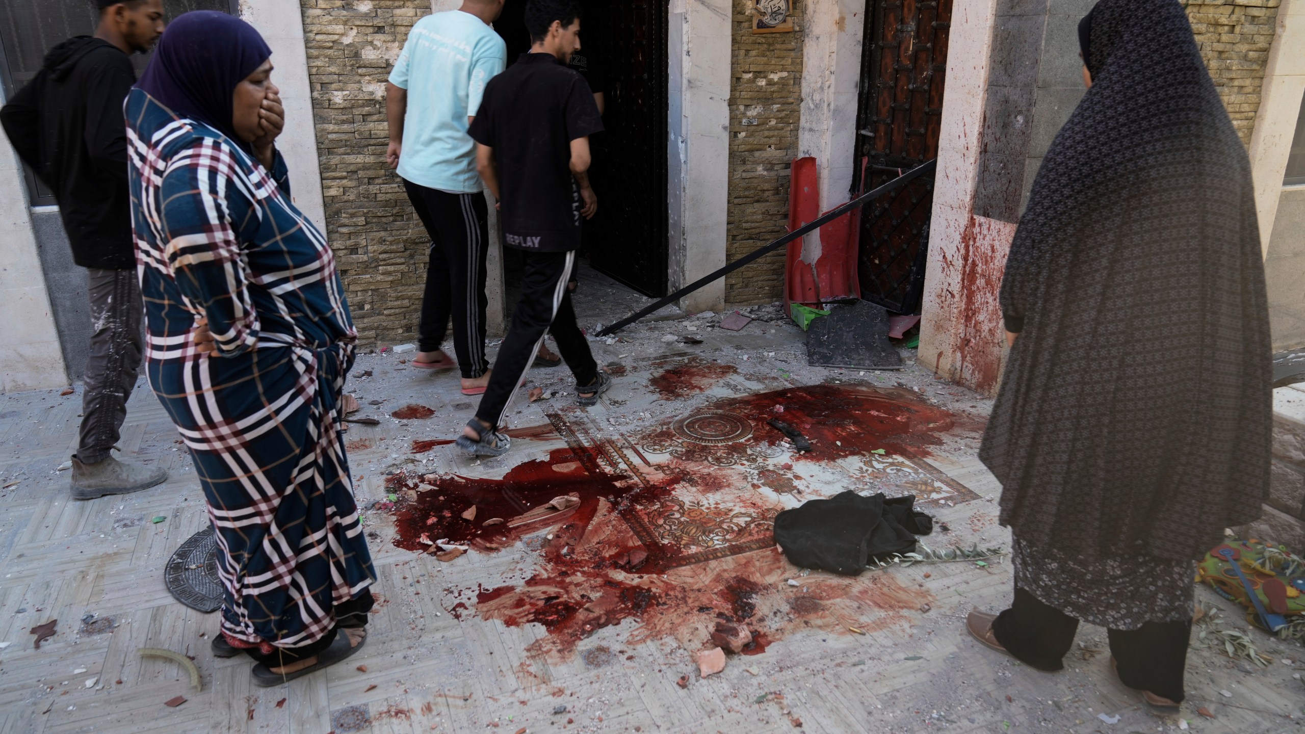 Palestinians look at blood stains at the site of an Israeli army raid where Palestinians say two were killed near Tulkarem, West Bank, Tuesday, Sept. 3, 2024. The dead were not immediately identified, but Israel launched a major offensive in the area last week in an operation it says is aimed against Palestinian militants. (AP Photo/Majdi Mohammed)