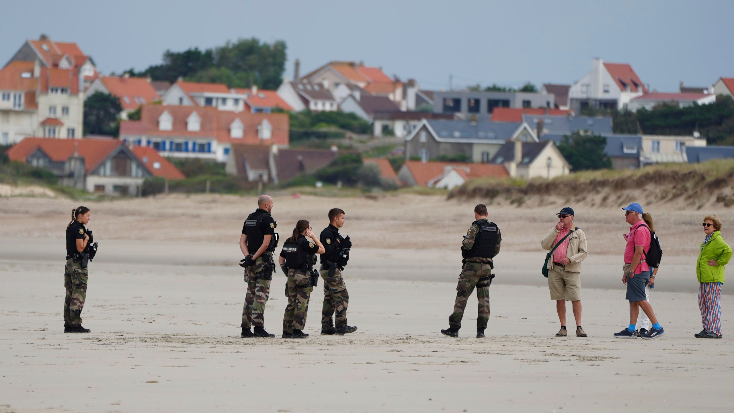 Police officers guard on the Wimereux beach, France, Wednesday, Sept. 4, 2024. A boat carrying migrants ripped apart in the English Channel as they attempted to reach Britain from northern France on Tuesday, plunging dozens into the treacherous waterway and leaving 12 dead, authorities said. (AP Photo/Nicolas Garriga)