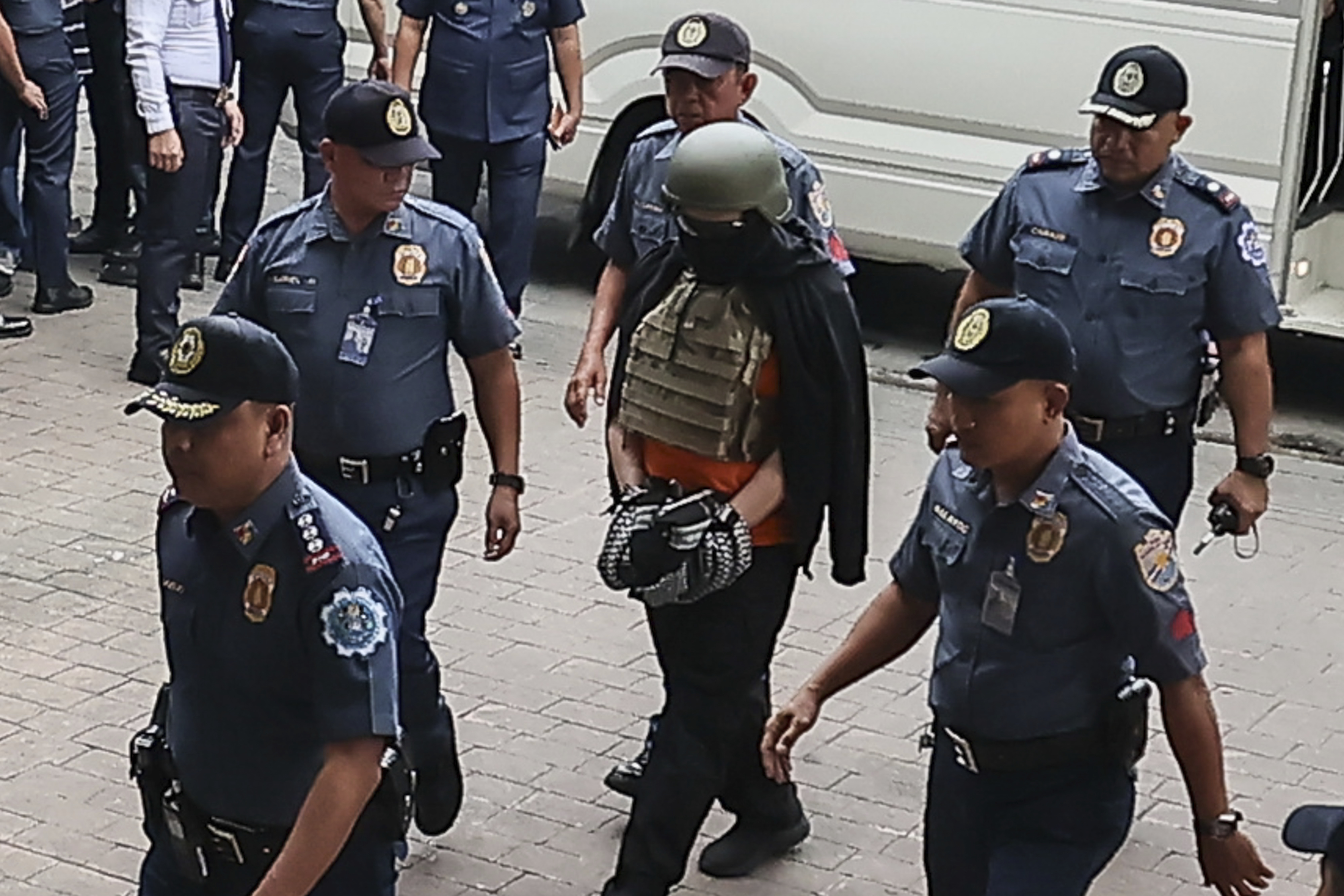 Apollo Carreon Quiboloy, wearing a helmet and flak jacket, a Filipino preacher charged with human trafficking, enters the Pasig Regional Trial Court in Pasig City, Philippines, Friday, Sept. 13, 2024. (AP Photo/Gerard Carreon)